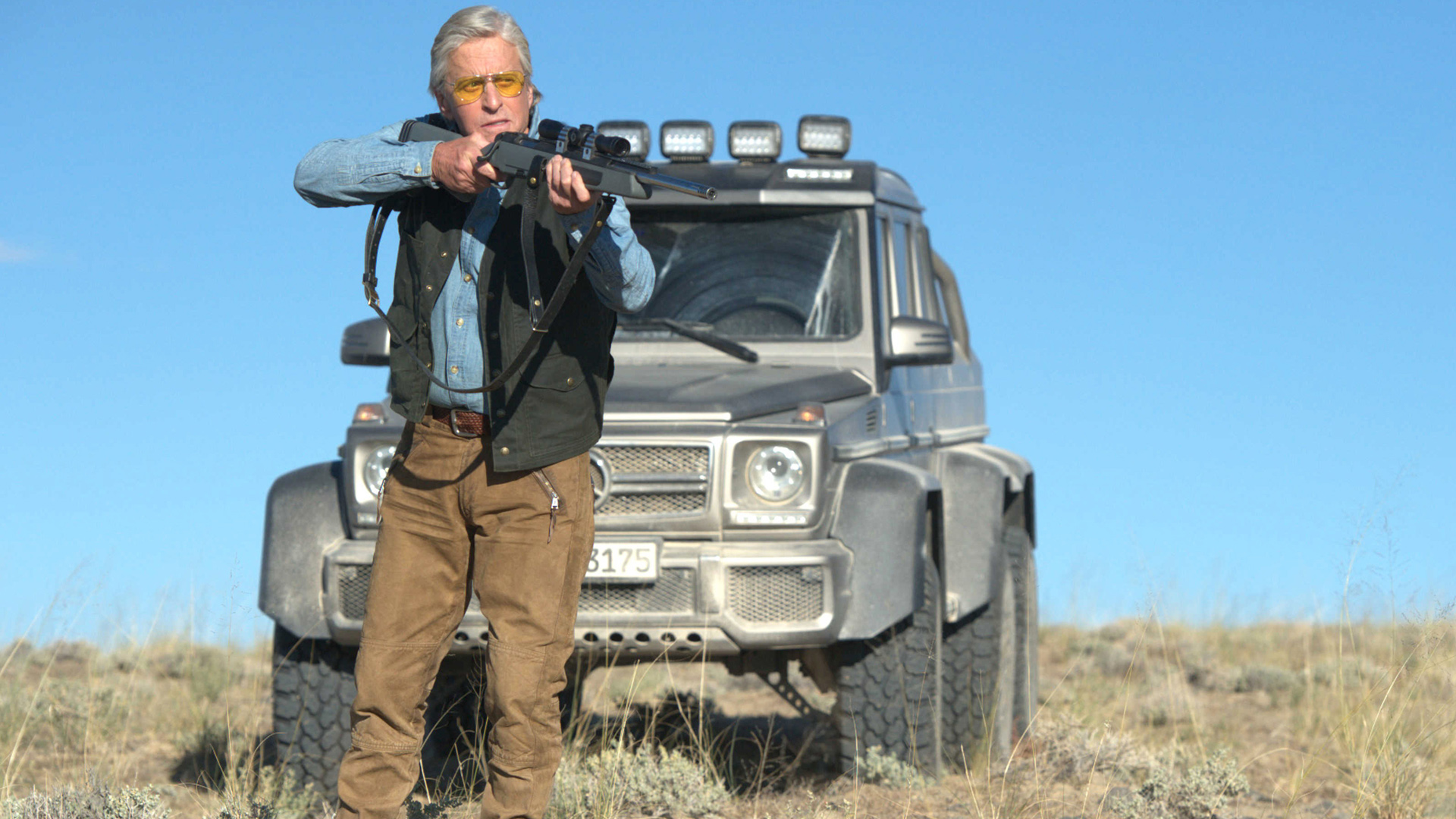 Michael Douglas with rifle and Mercedes-Benz G-Wagen HD Wallpaper