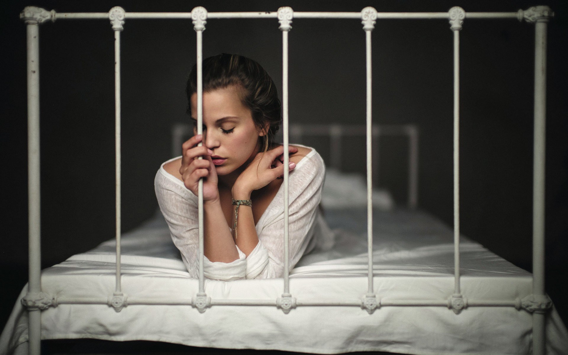 Woman lying on a bed behind bars HD Wallpaper