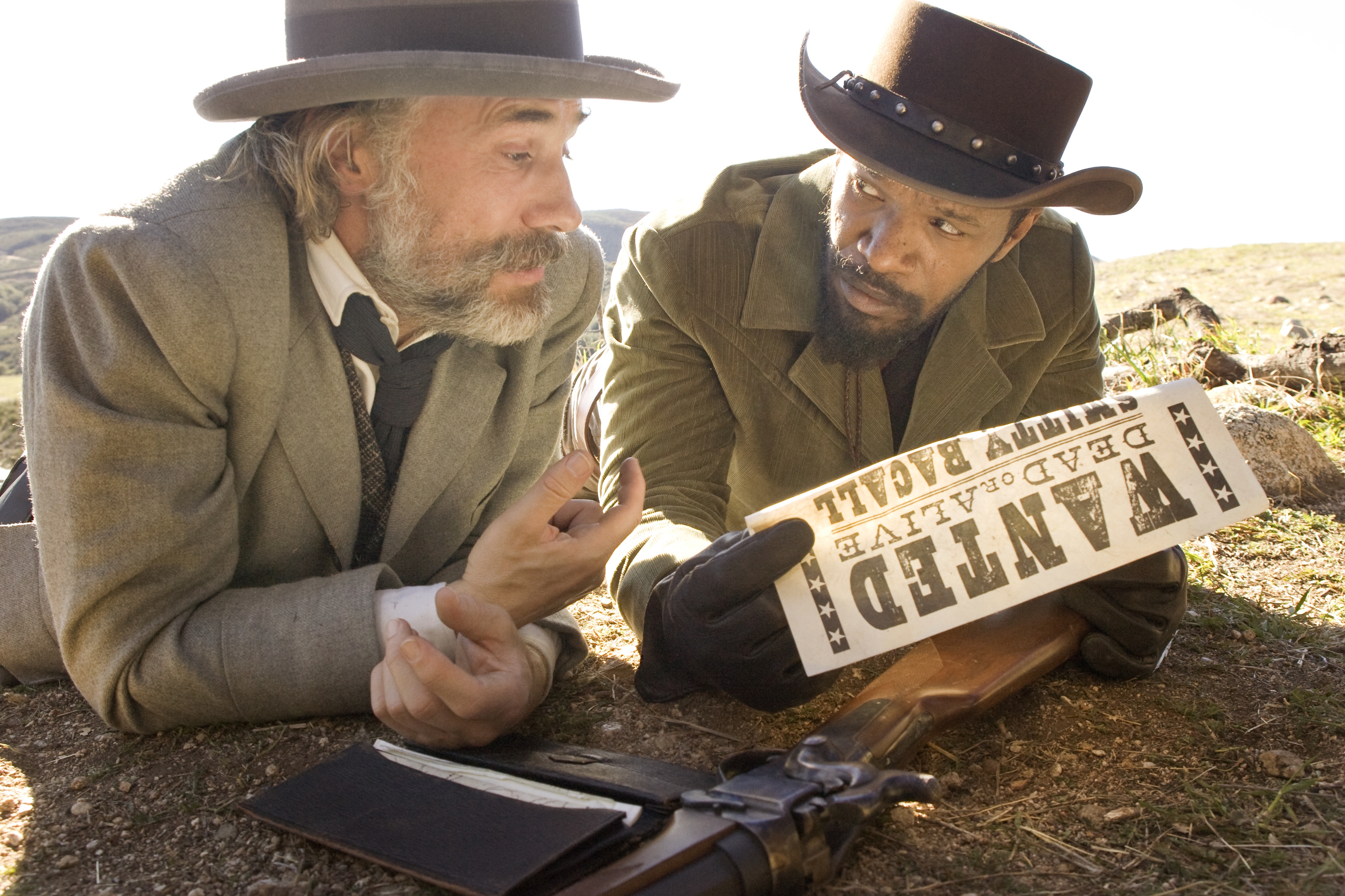 Christoph Waltz and Jamie Foxx look at wanted poster HD Wallpaper