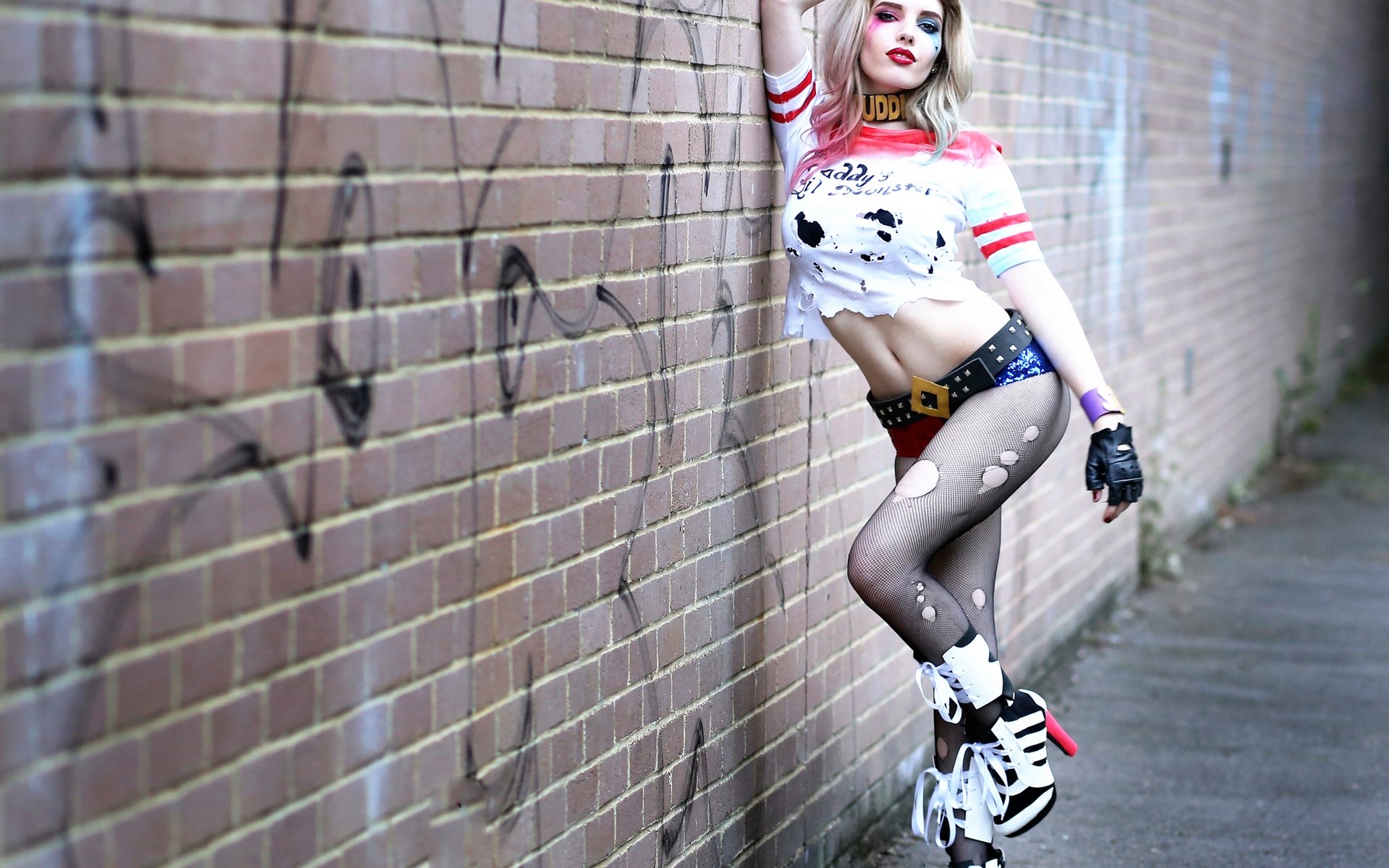 Harley Quinn from DC Comics leaning on a brick wall HD Wallpaper