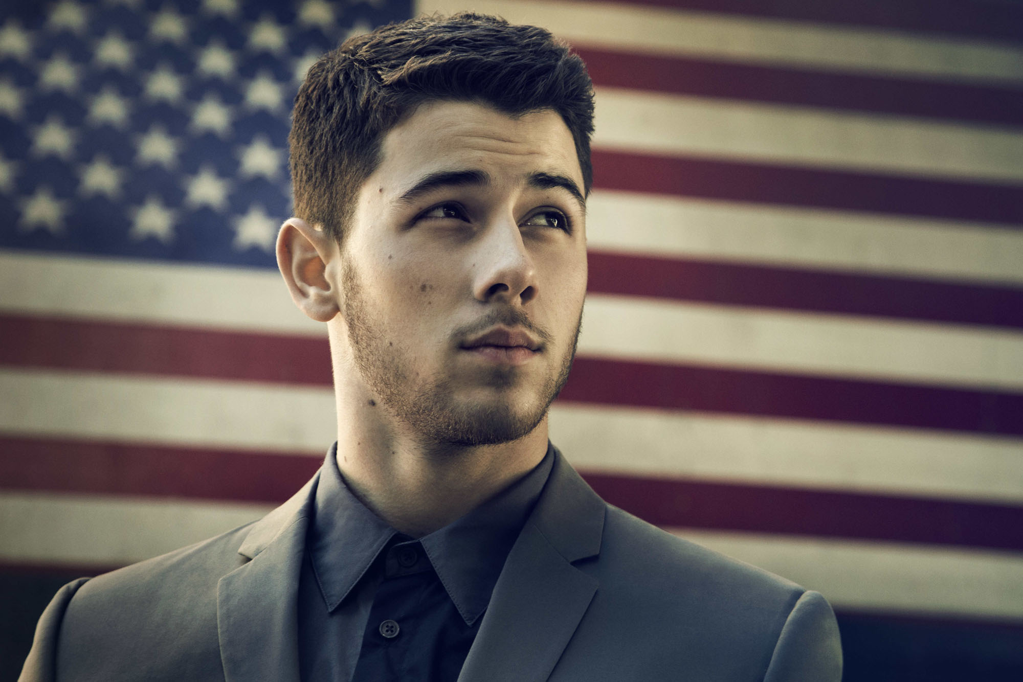 Nick Jonas in front of American flag HD Wallpaper
