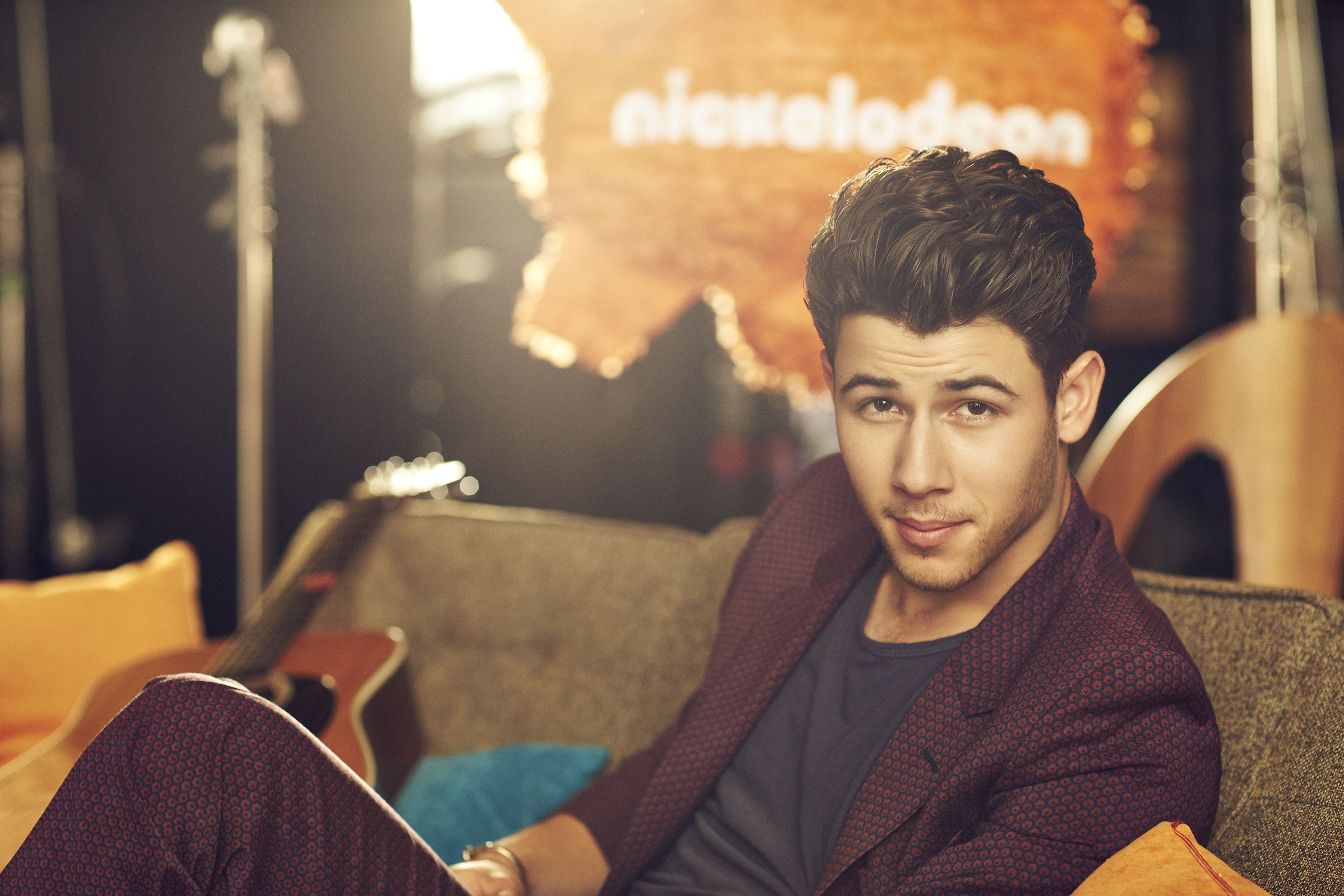 Nick Jonas in front of Nickelodeon logo HD Wallpaper