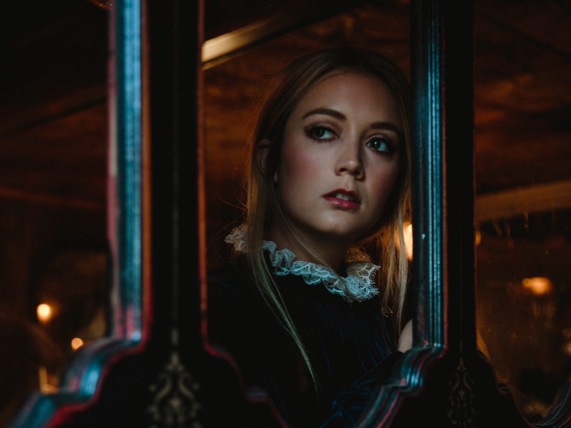 Billie Lourd in a dark, ornate setting HD Wallpaper