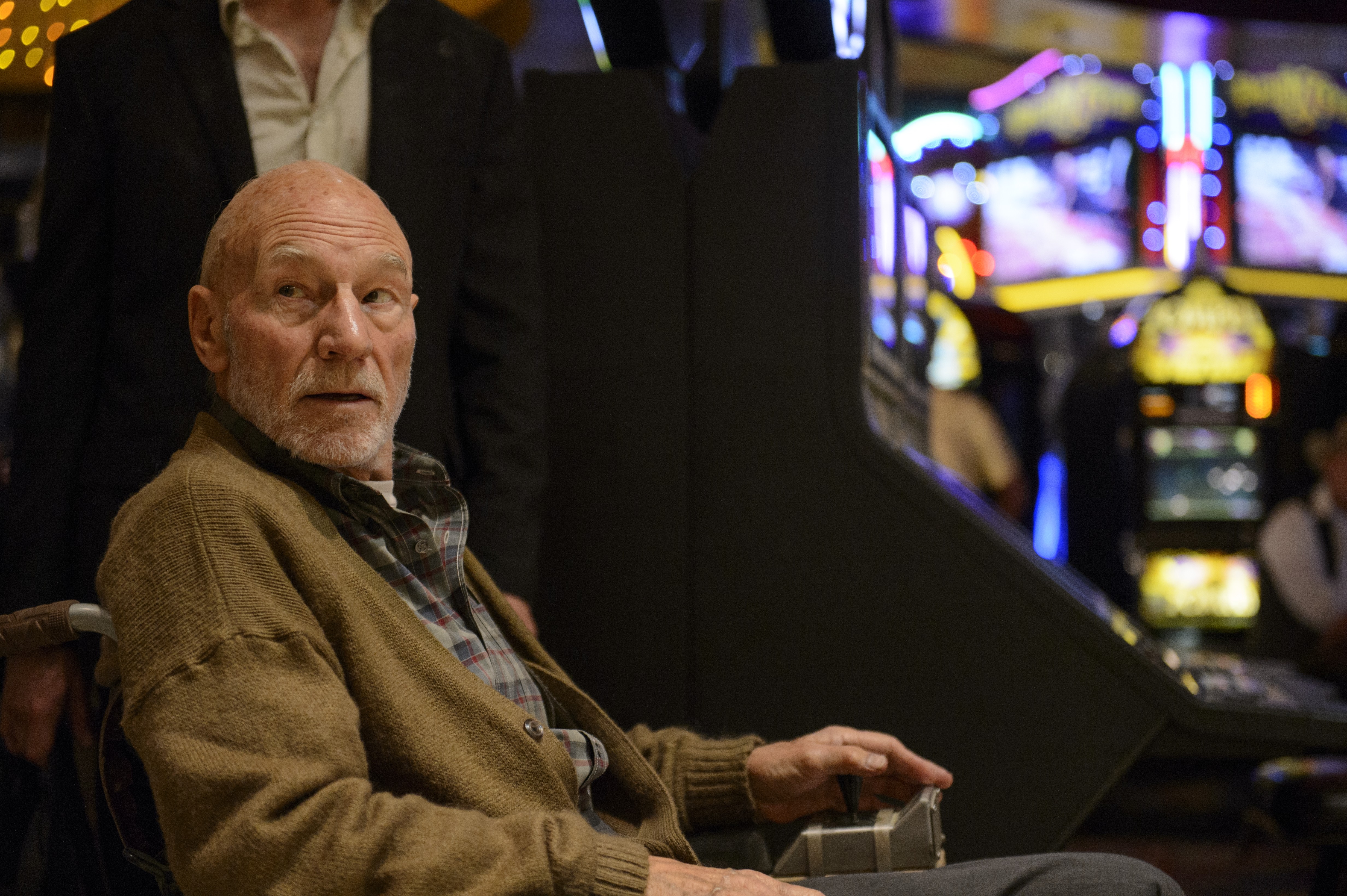 Patrick Stewart in a wheelchair at a casino HD Wallpaper