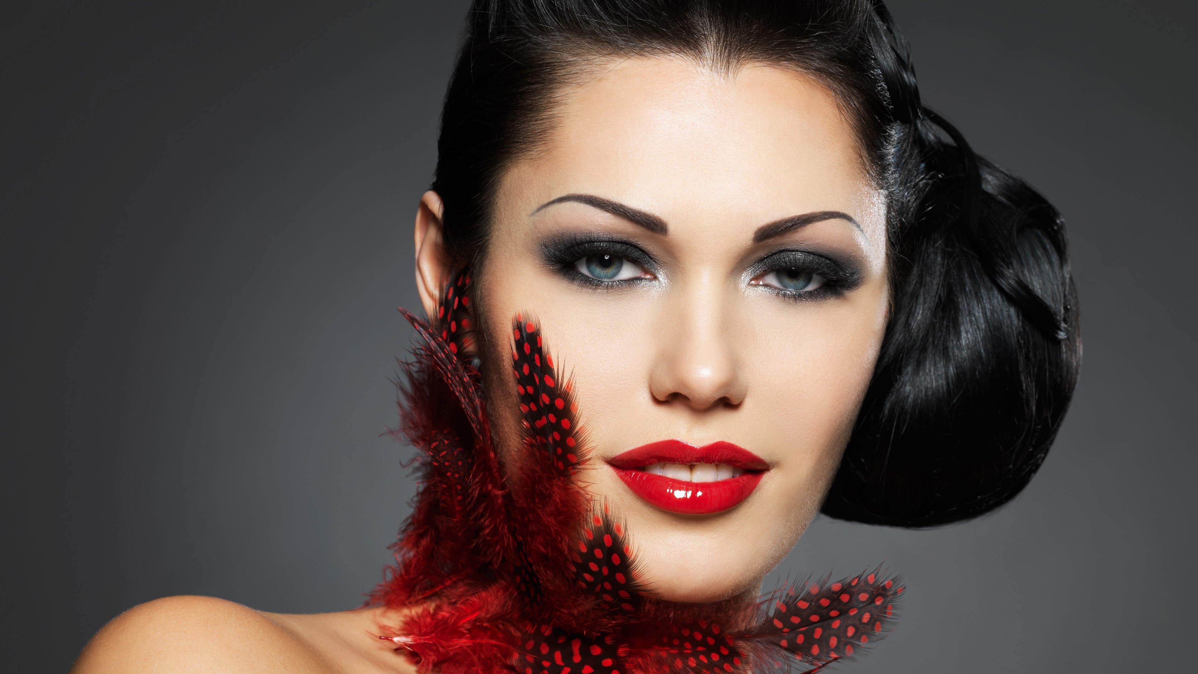 Woman with red feathers and dramatic makeup HD Wallpaper
