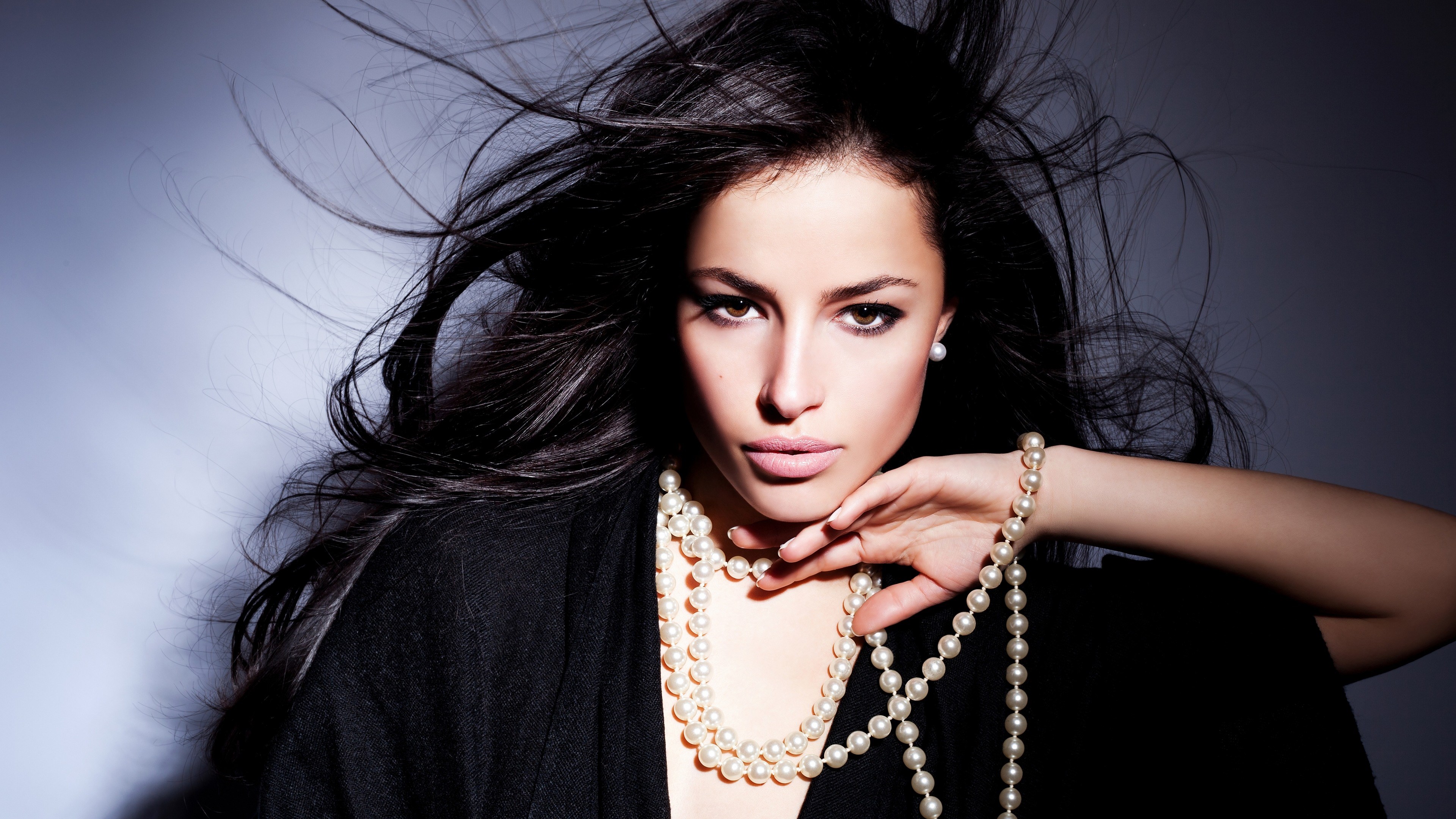 Woman with dark hair and pearl necklace HD Wallpaper