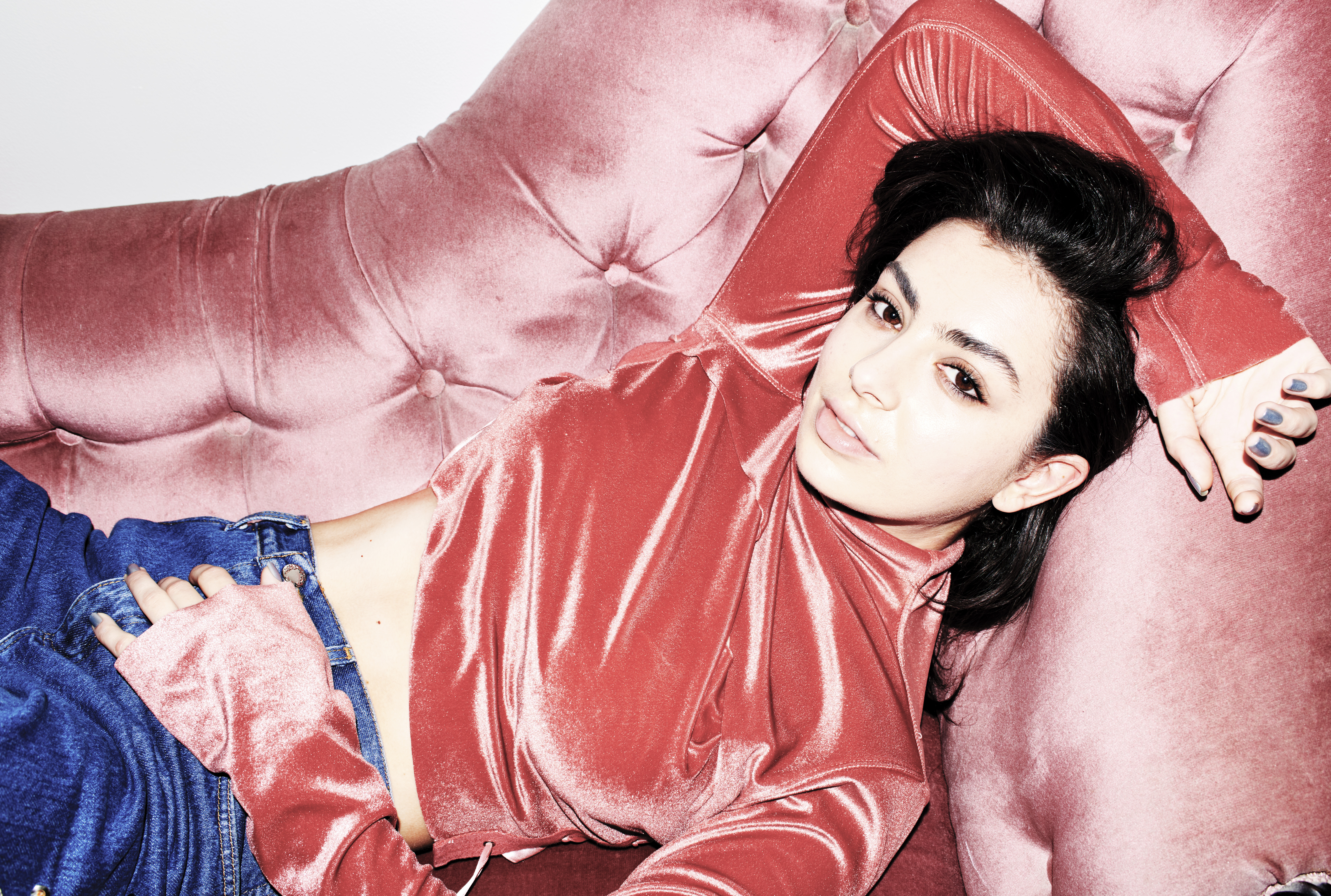 Charli XCX lying on a pink couch HD Wallpaper