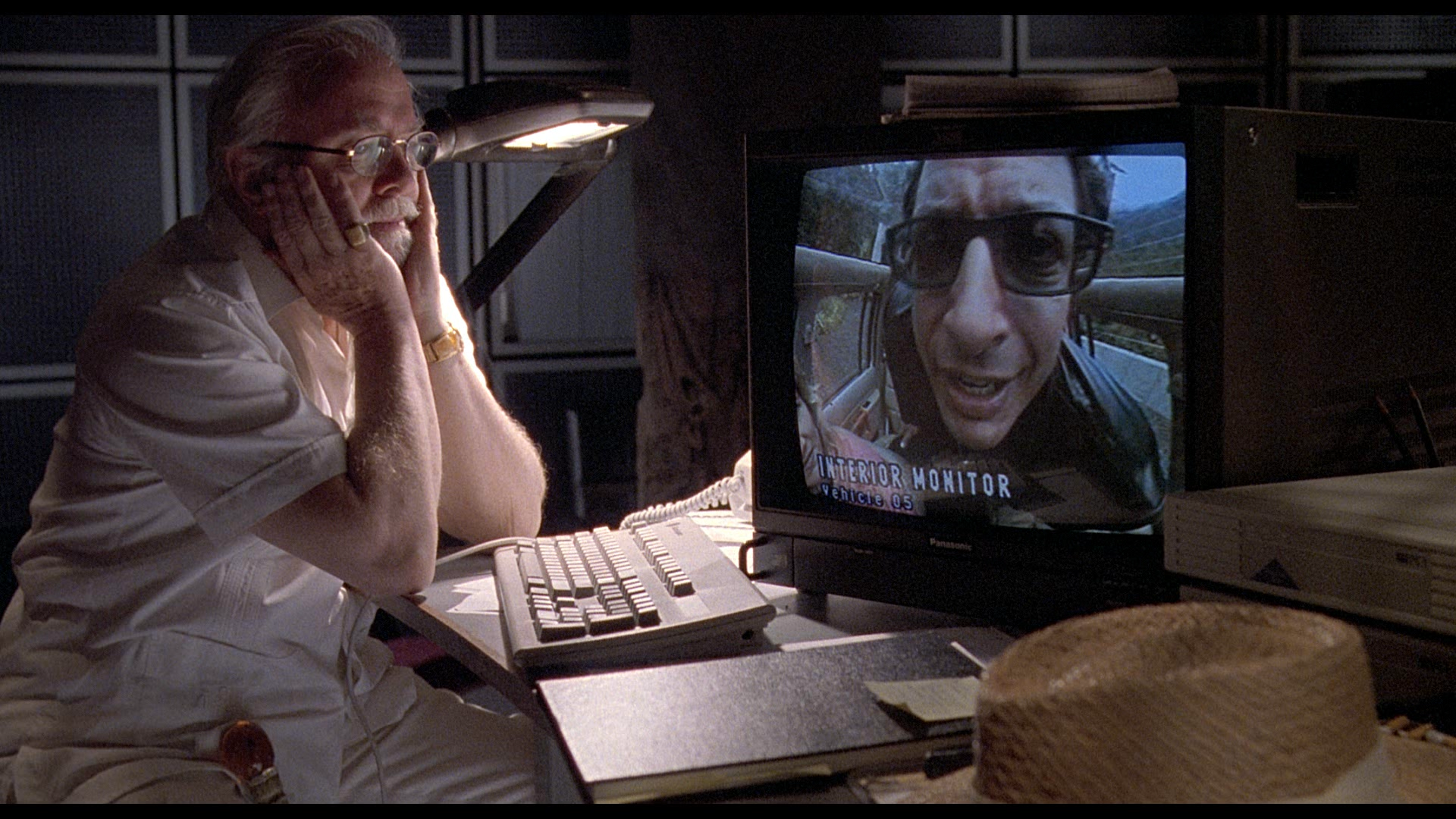 Man watching Jeff Goldblum on monitor HD Wallpaper