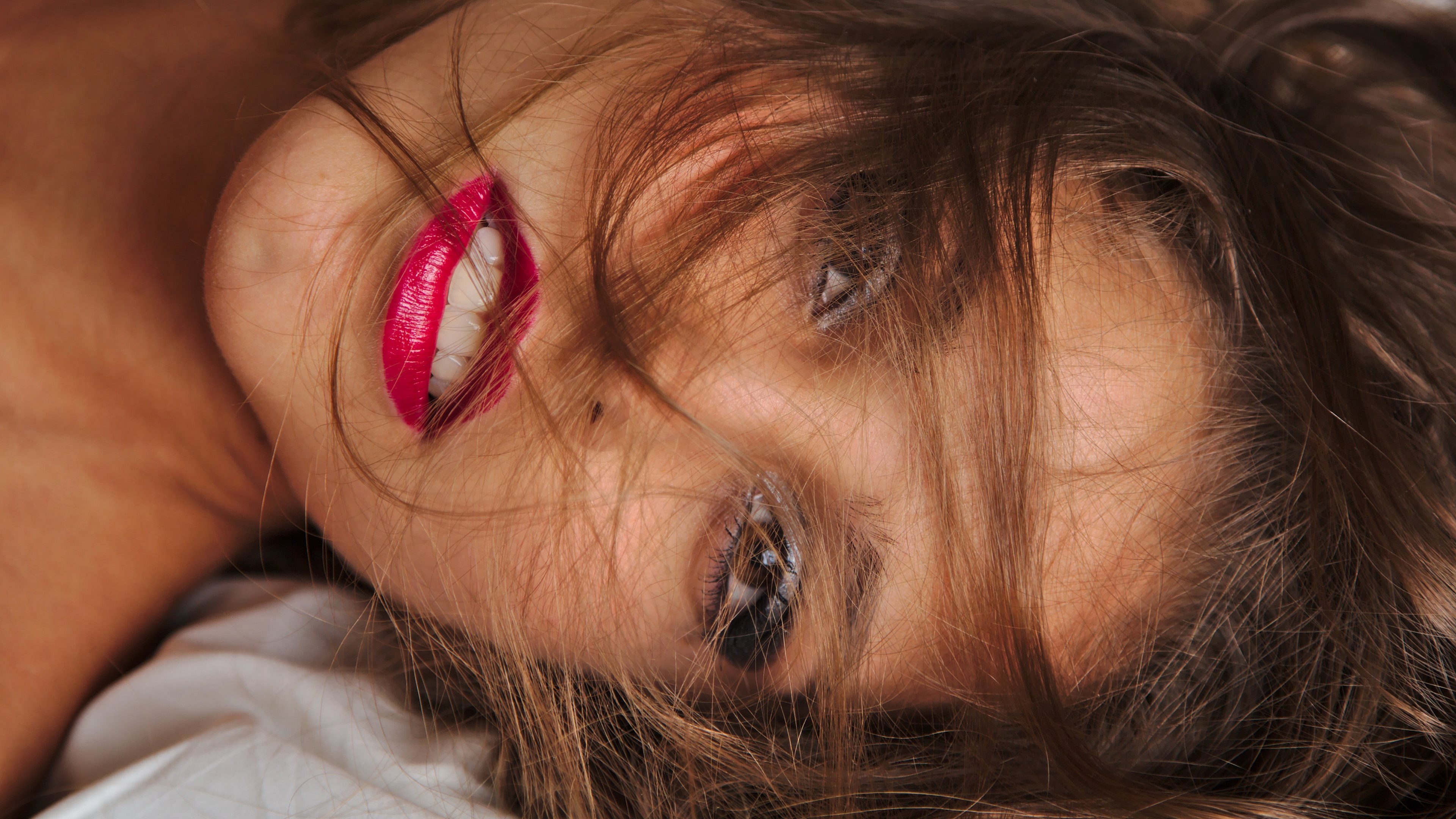 Woman with bright red lipstick lying down HD Wallpaper