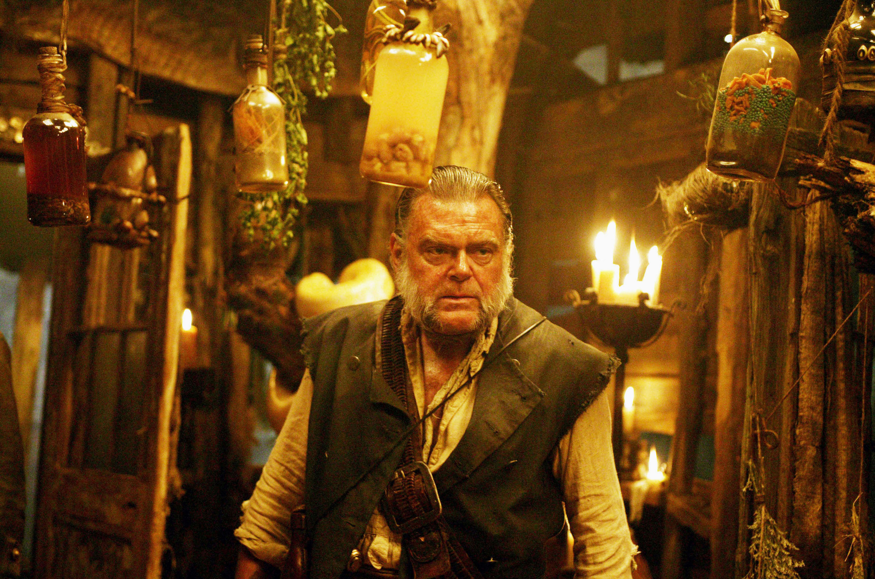 Kevin McNally in a dimly lit, rustic interior HD Wallpaper