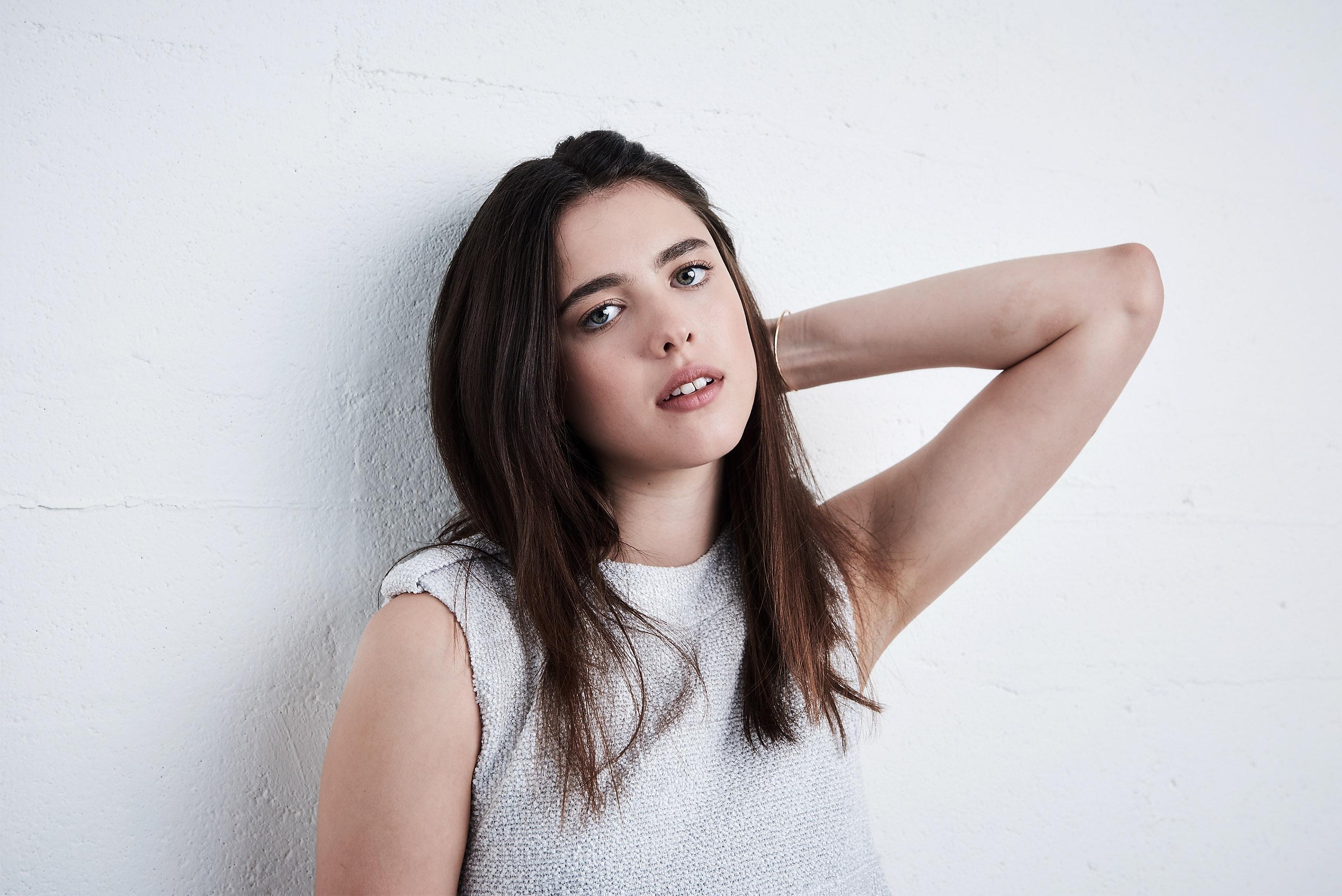 Margaret Qualley leaning against a white wall HD Wallpaper