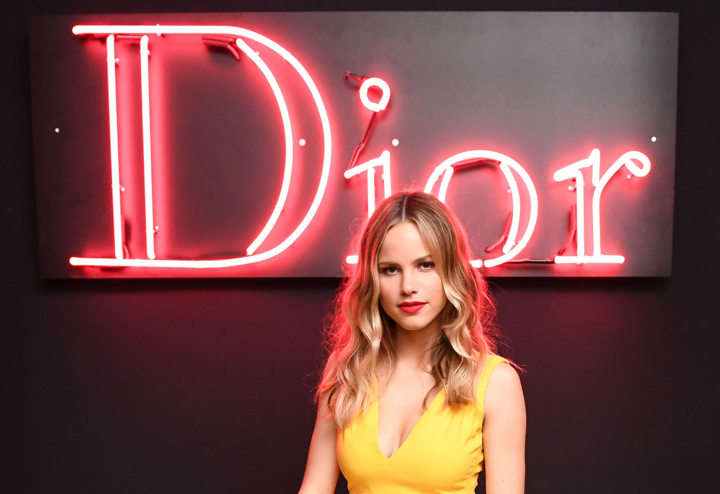 Halston Sage in front of Dior neon sign HD Wallpaper