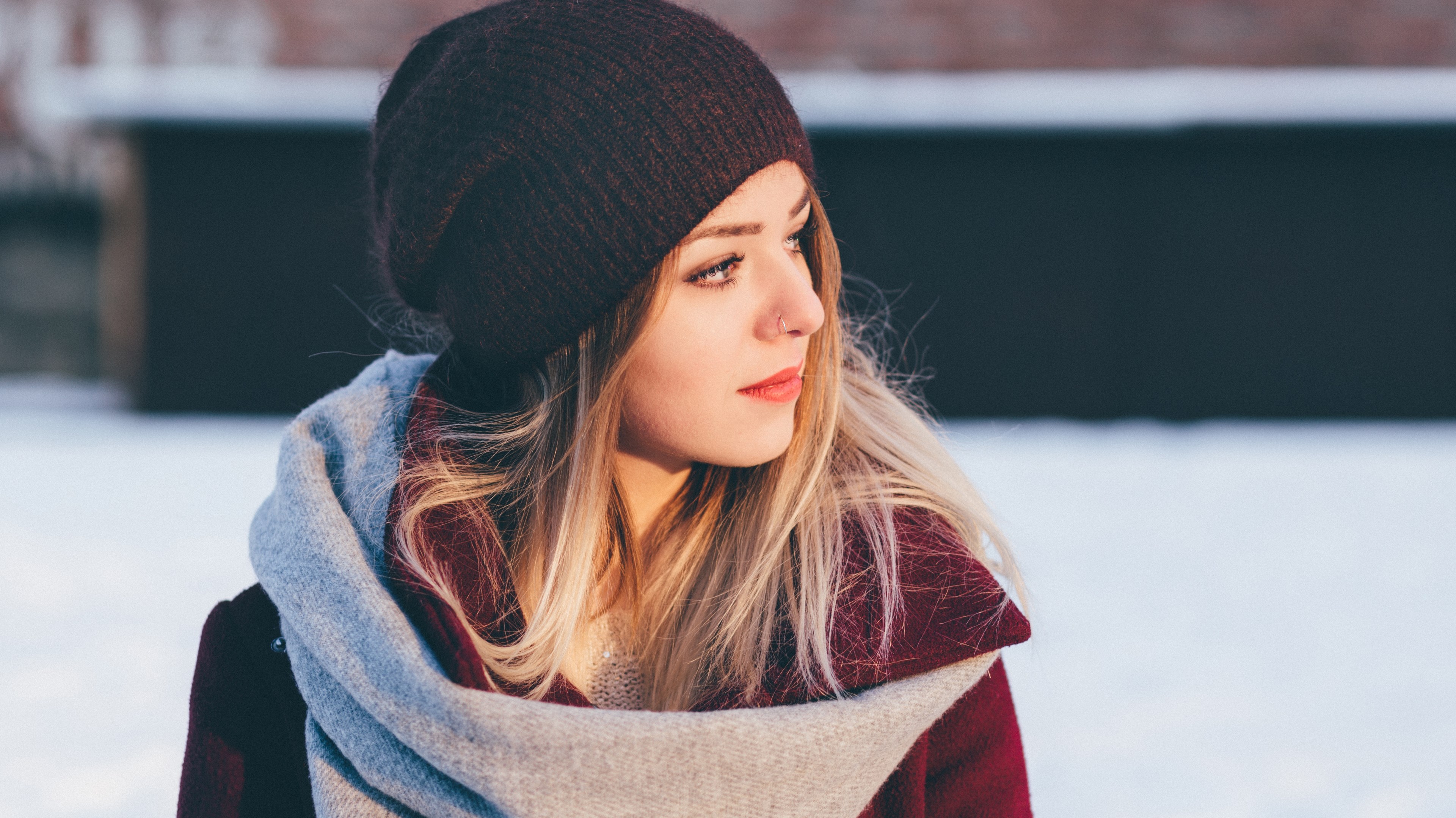 Woman wearing a beanie and scarf in the snow HD Wallpaper