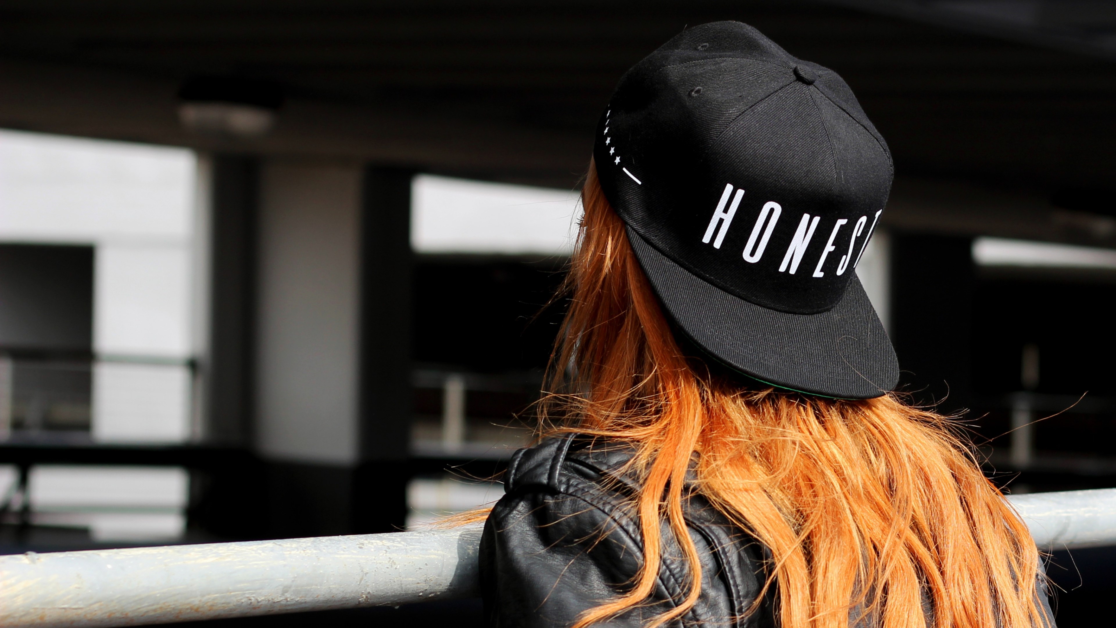 Person wearing a black cap with "HONEST" text HD Wallpaper