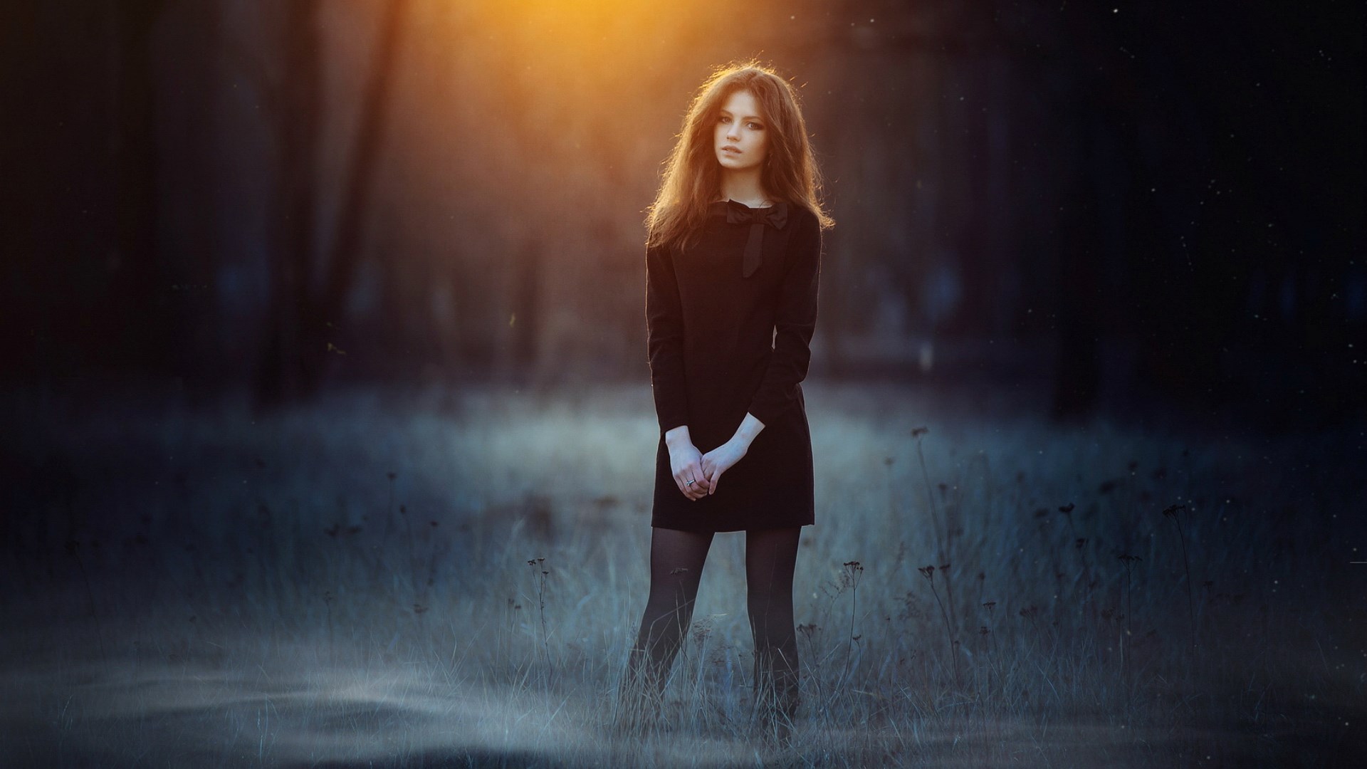 Young woman in black dress standing in a field HD Wallpaper