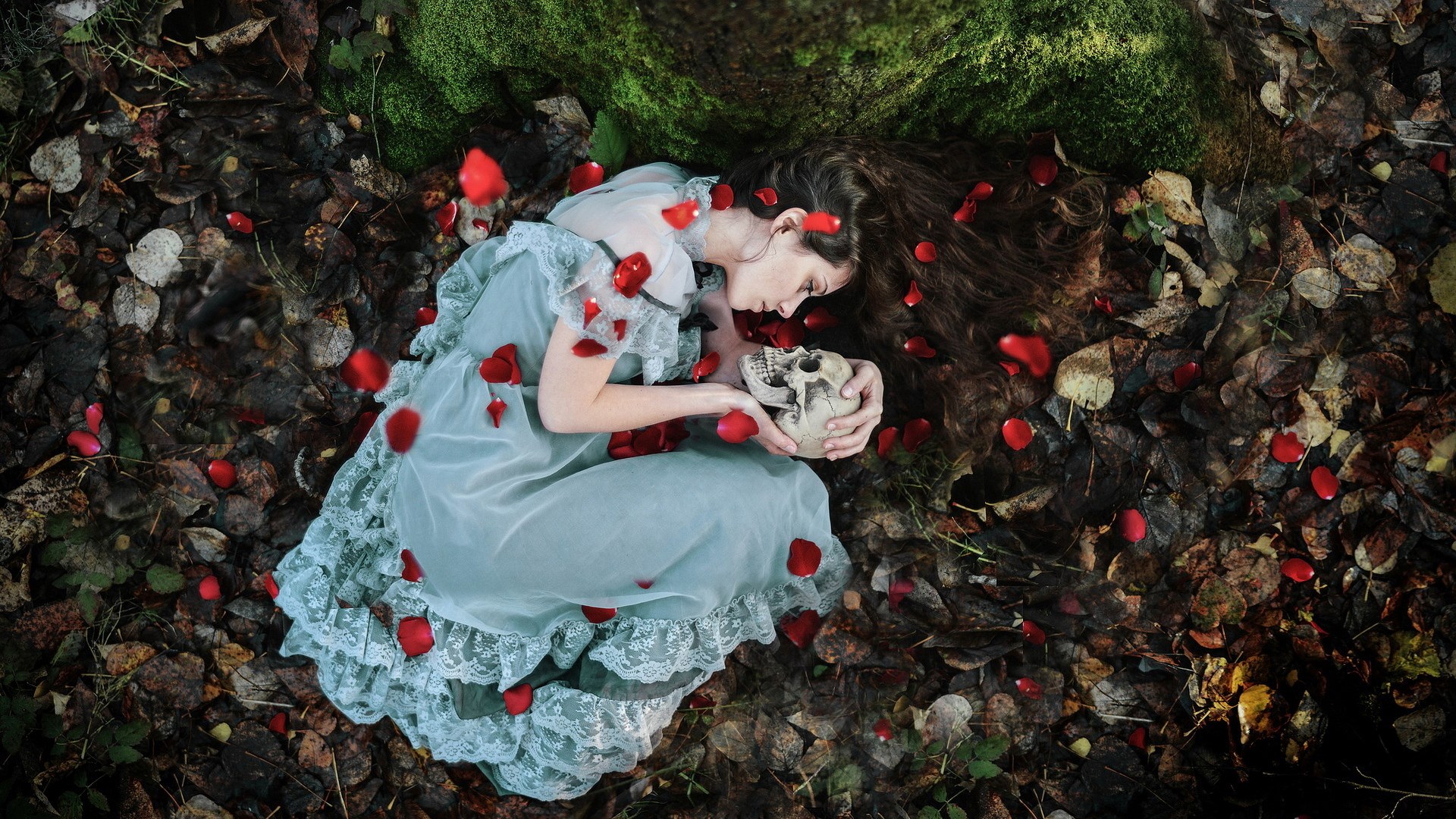 Woman in dress holding a skull surrounded by rose petals HD Wallpaper