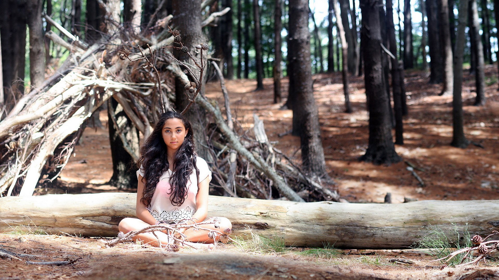 Young woman sitting in a forest HD Wallpaper