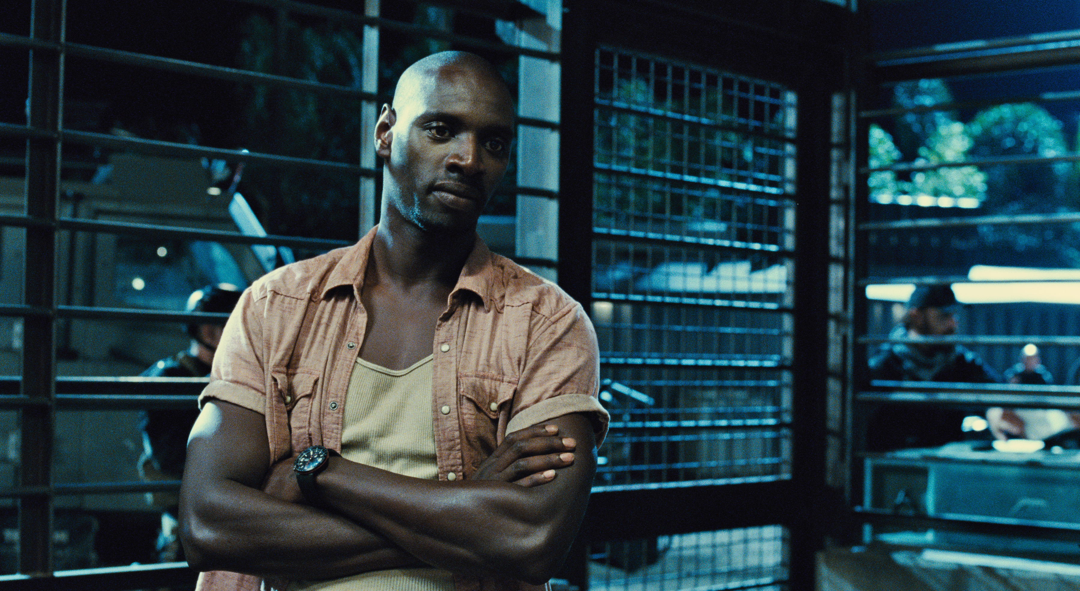 Omar Sy in a dimly lit room HD Wallpaper