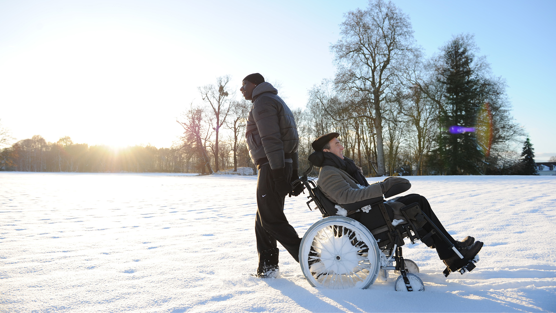 Omar Sy in a wheelchair in the snow HD Wallpaper