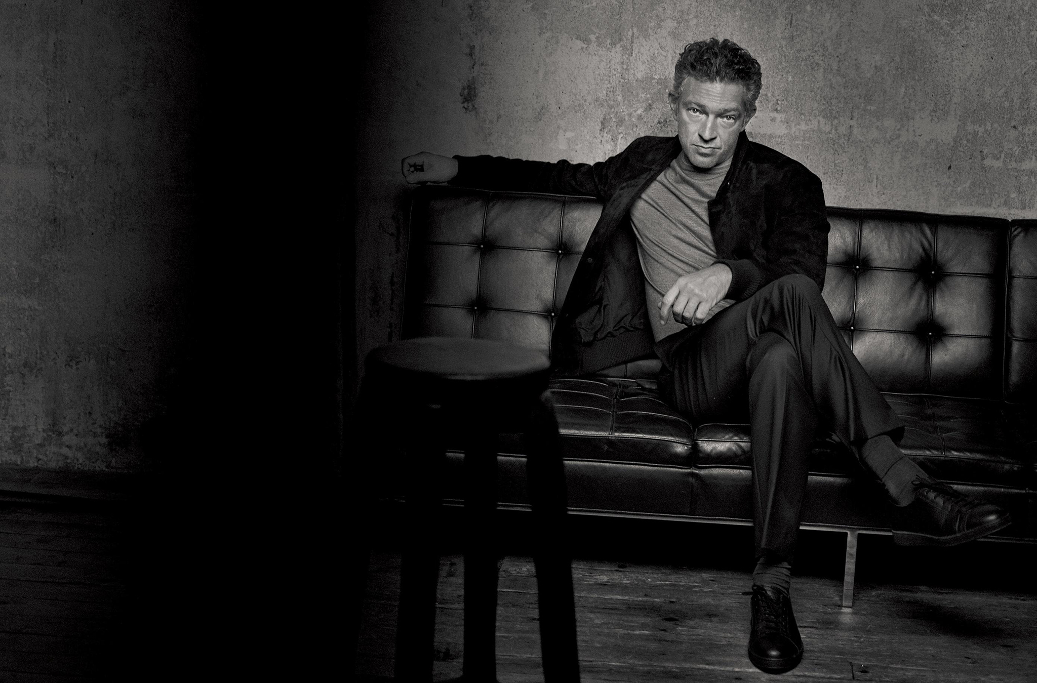 Vincent Cassel sitting on a leather couch HD Wallpaper