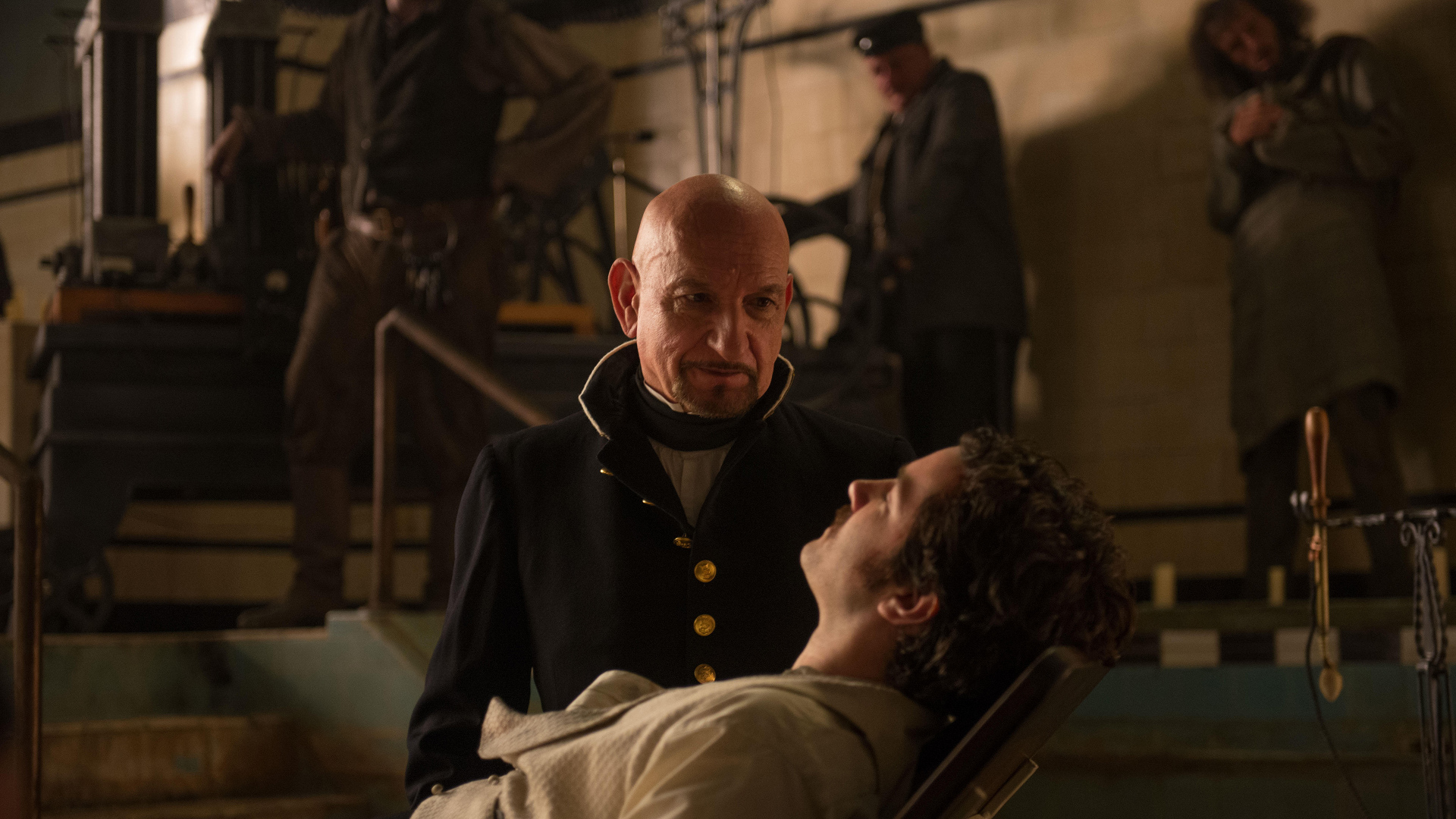 Ben Kingsley in a dark room with other people HD Wallpaper