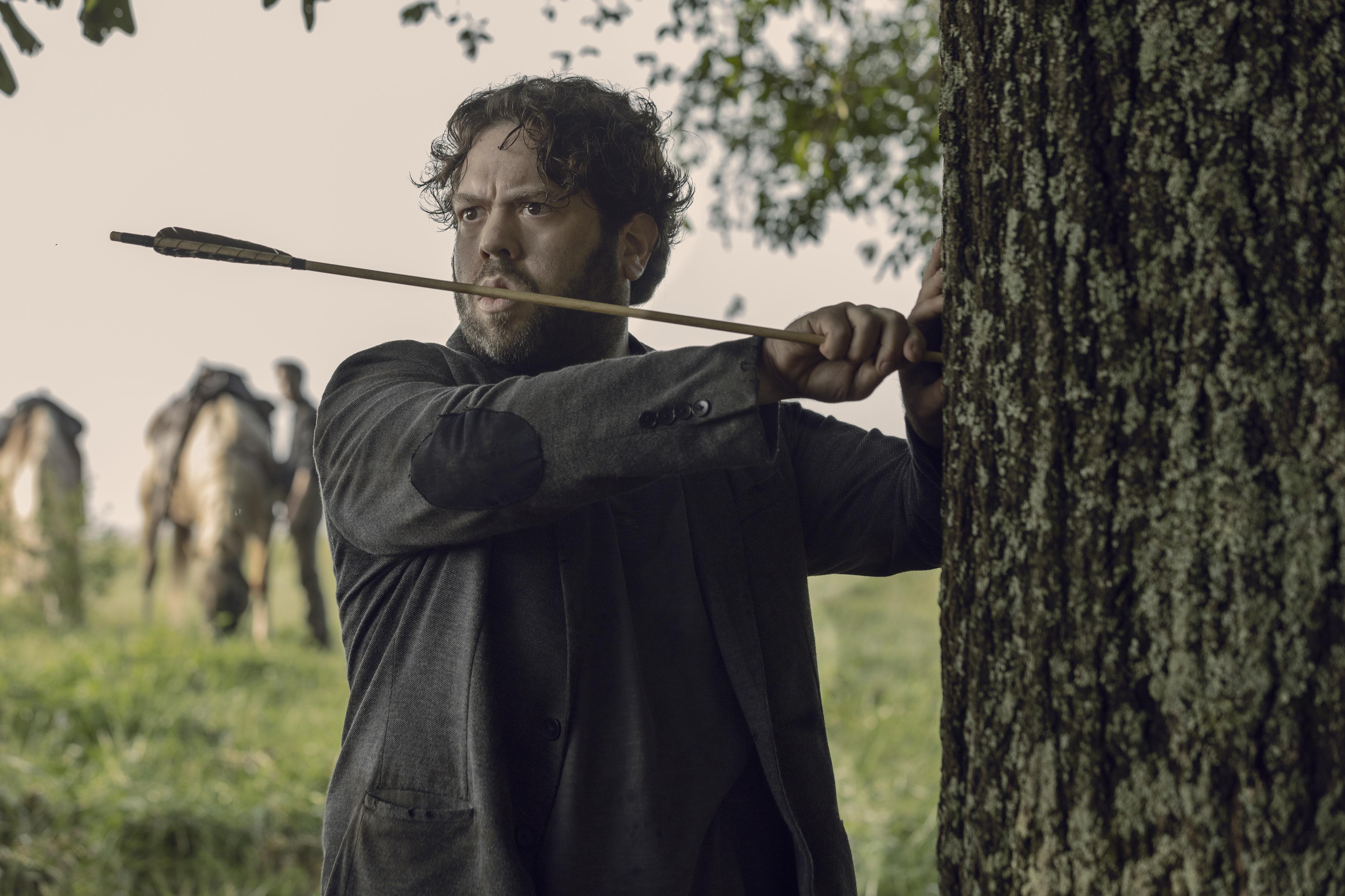 Dan Fogler aiming an arrow behind a tree HD Wallpaper