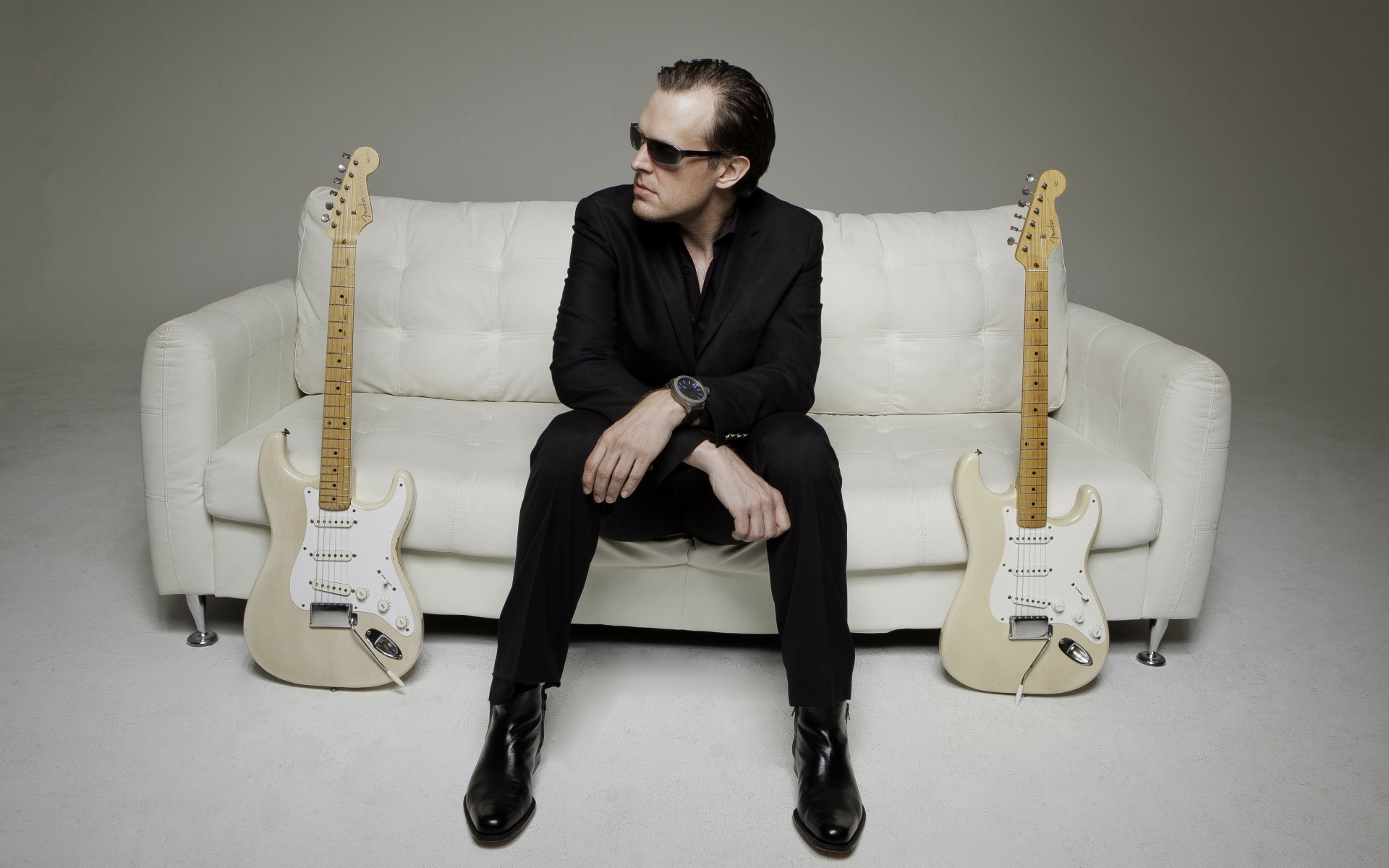 Joe Bonamassa sitting on a couch with guitars HD Wallpaper