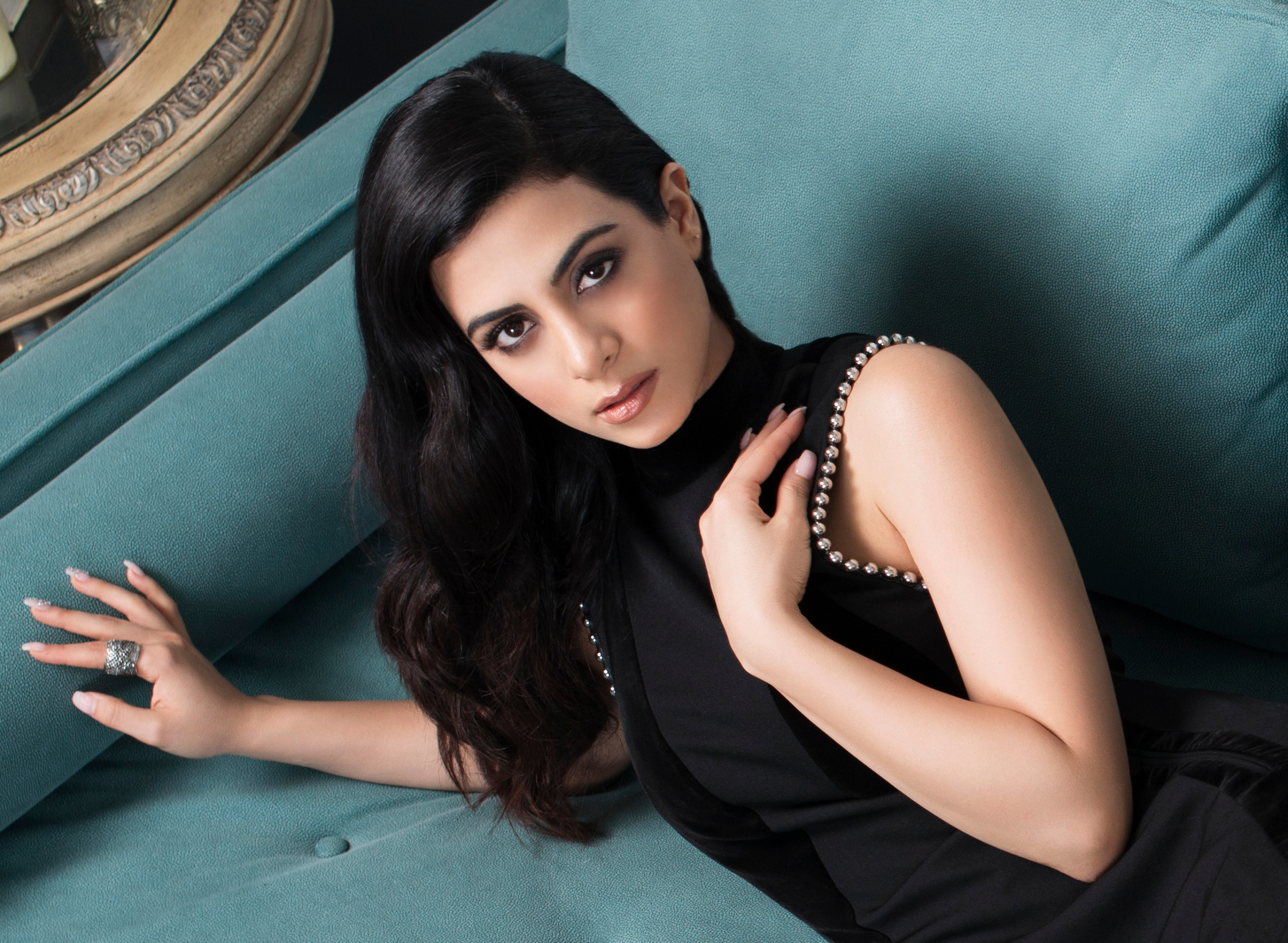 Emeraude Toubia on a teal couch HD Wallpaper