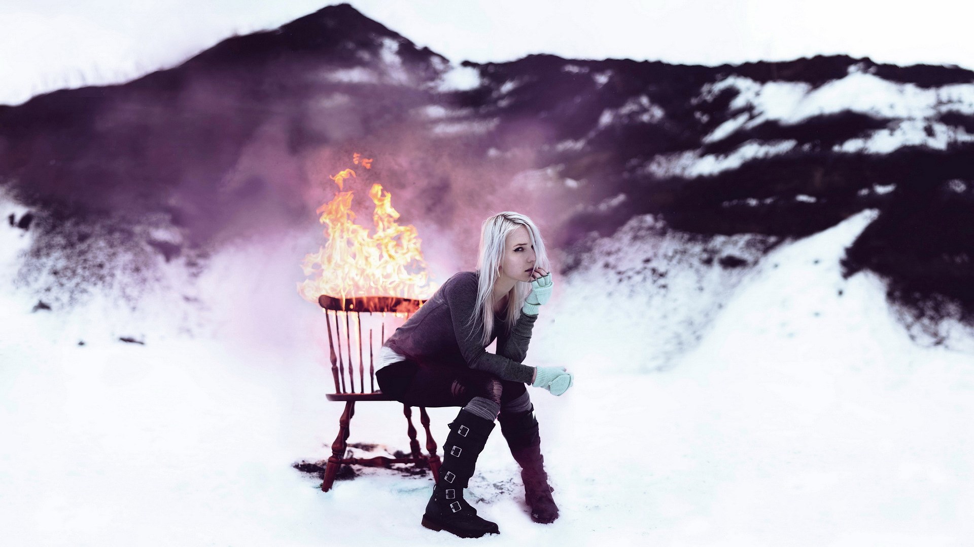 Woman sitting on a burning chair in a snowy landscape HD Wallpaper