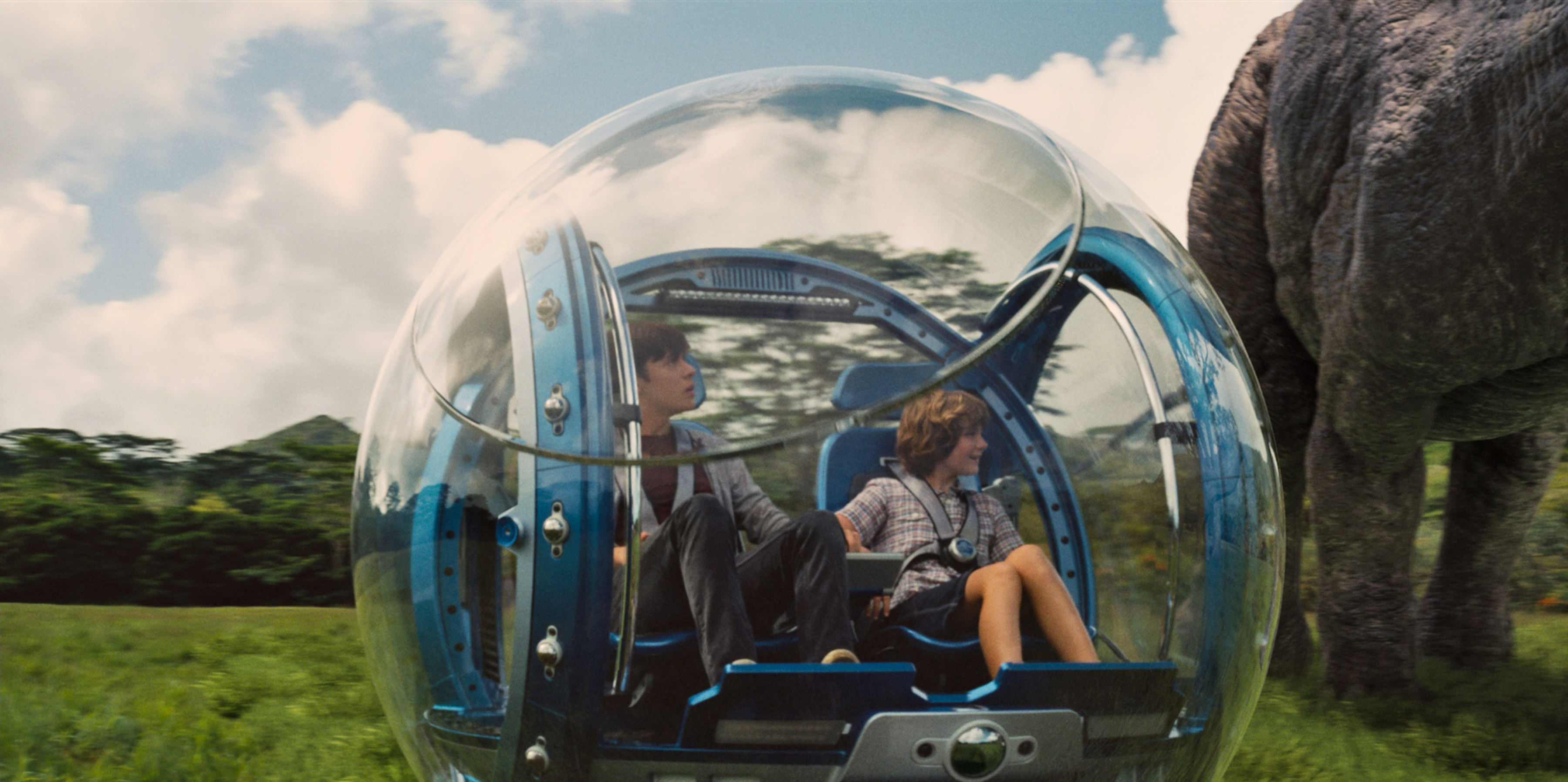 Two children in a gyrosphere with a dinosaur HD Wallpaper