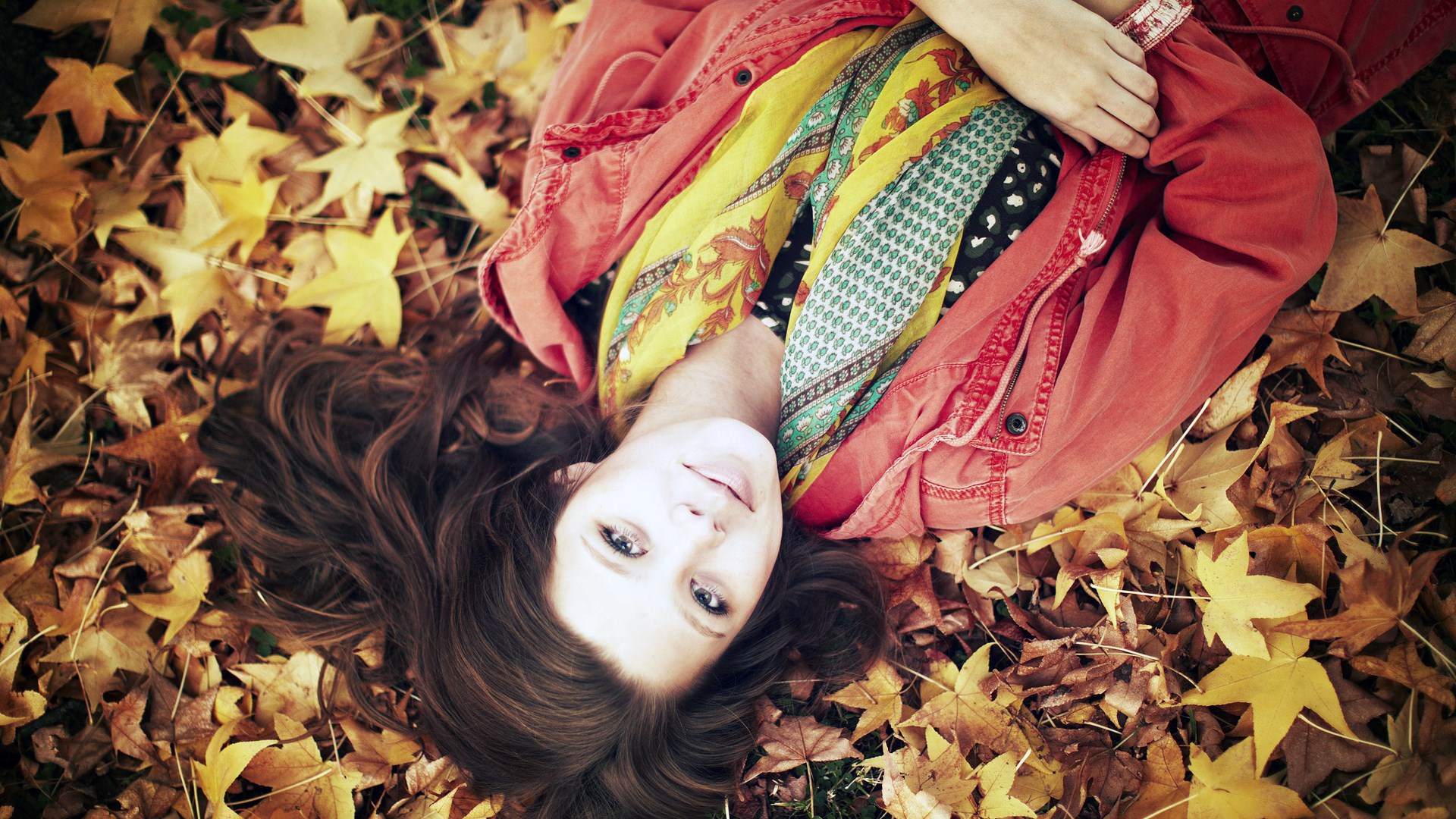 Woman lying in autumn leaves HD Wallpaper