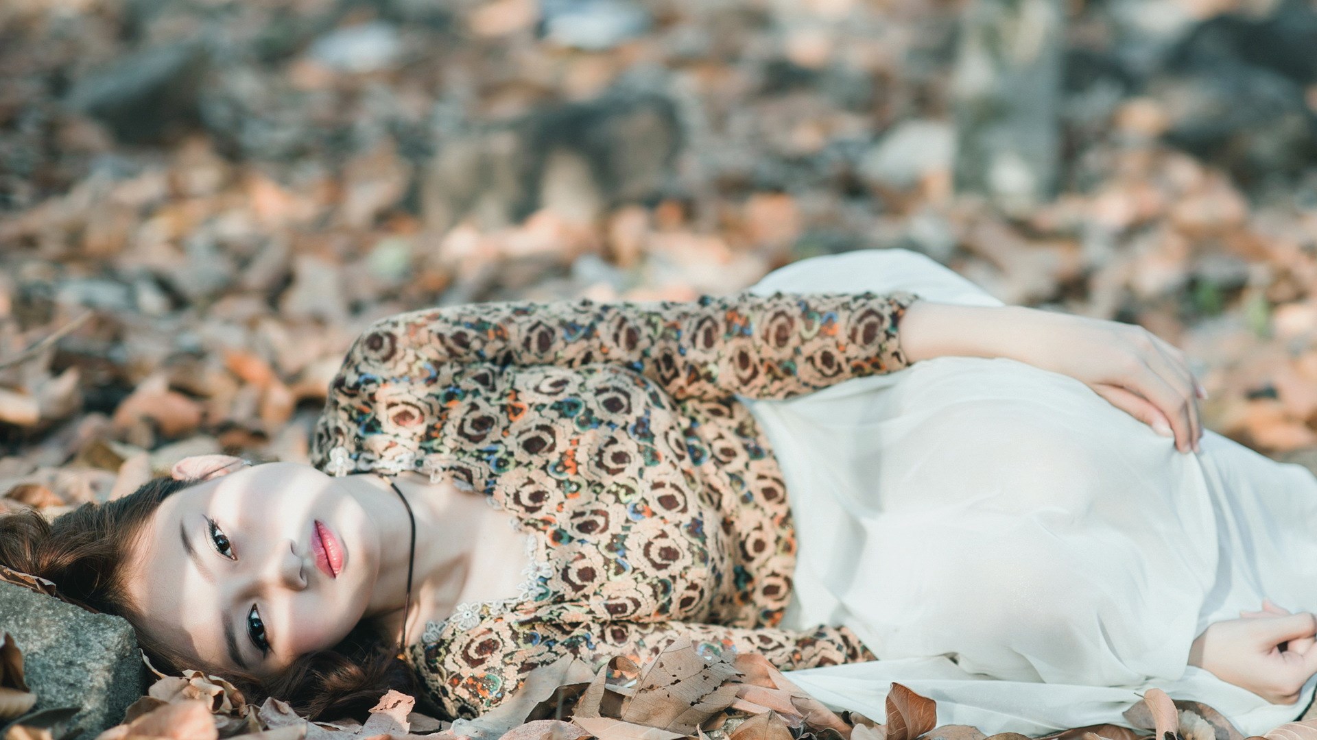 Woman lying on autumn leaves HD Wallpaper