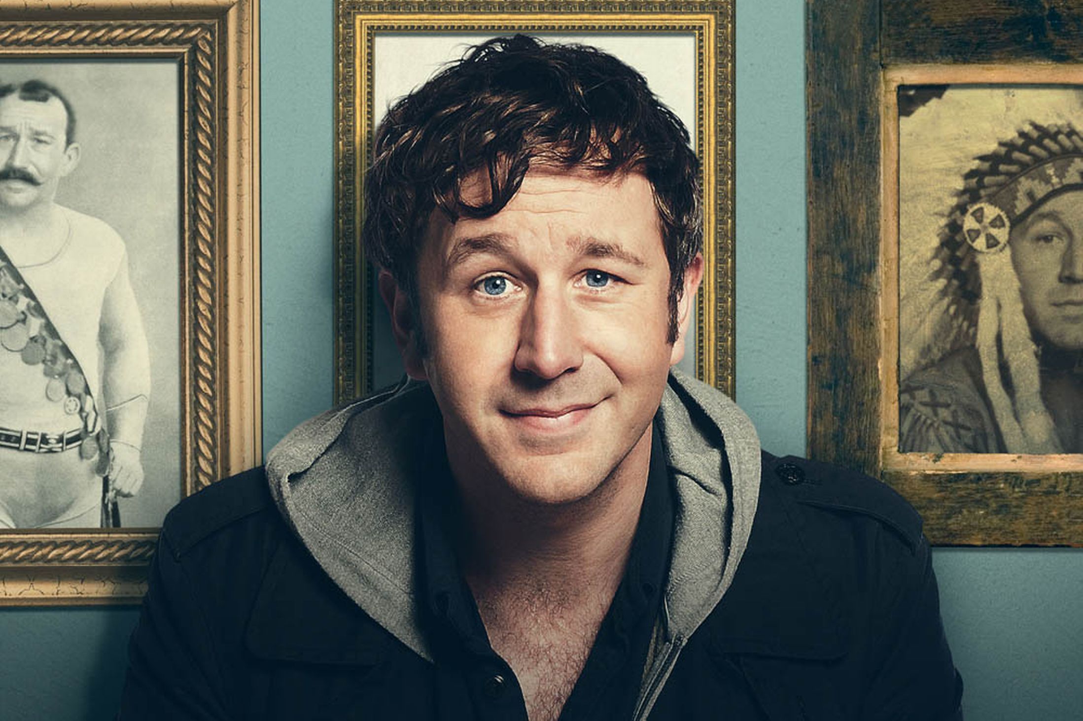 Chris O'Dowd in front of framed portraits HD Wallpaper