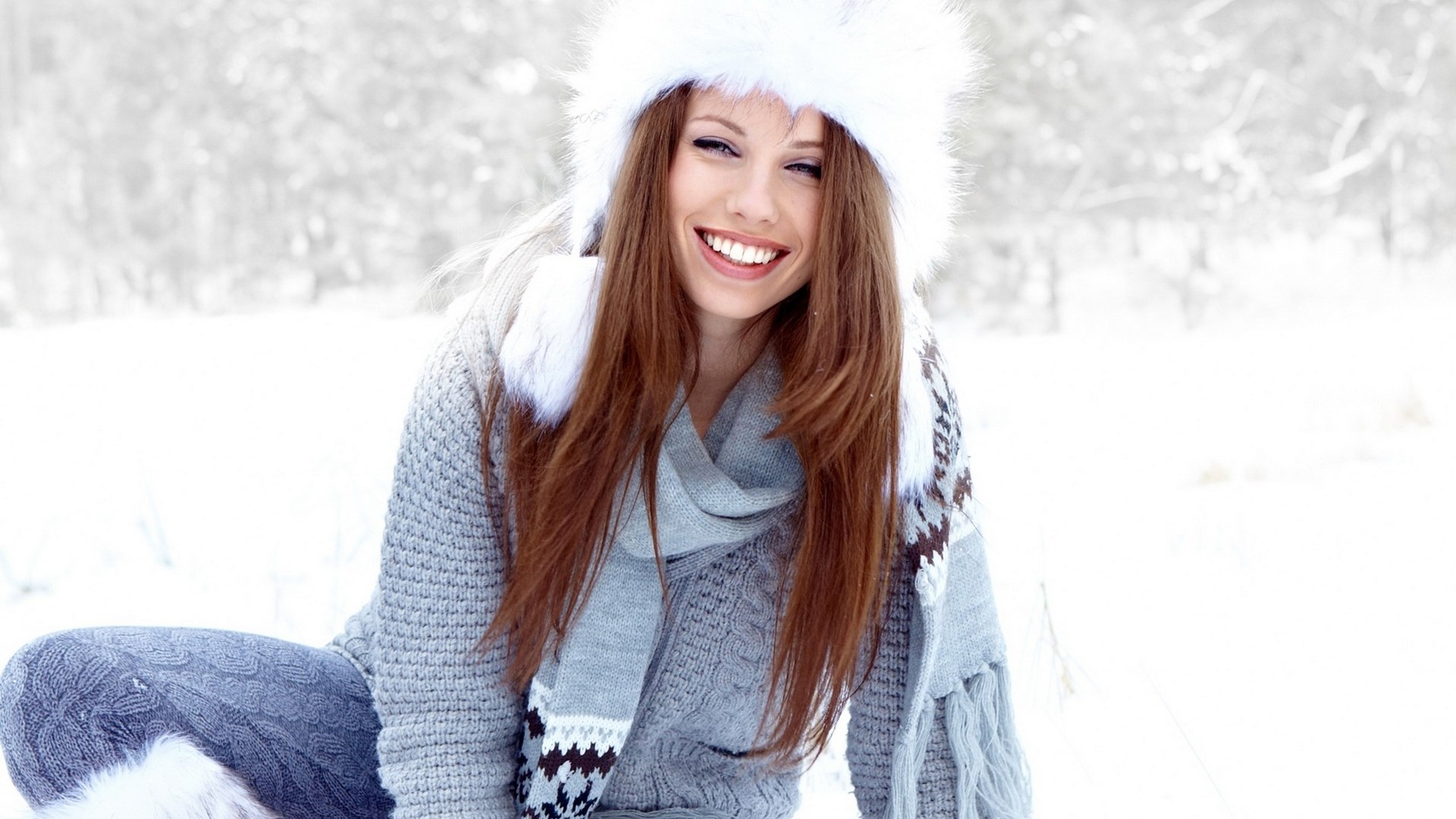 Woman in winter hat and scarf smiling in snow HD Wallpaper