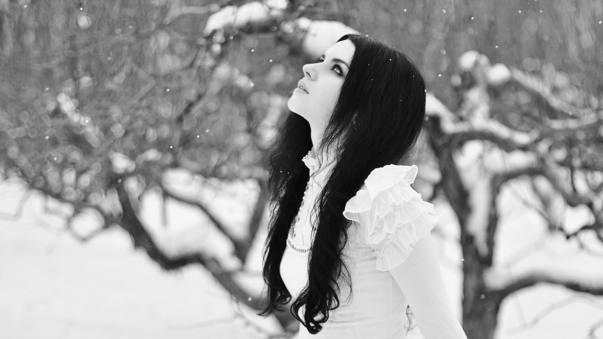 Woman in white dress looking up at snow HD Wallpaper