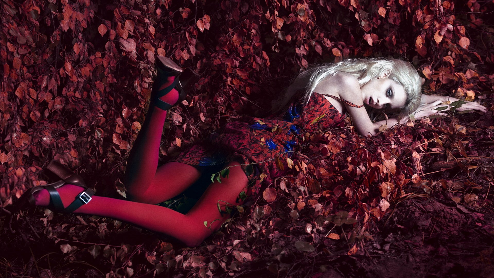 Woman in red dress and stockings lying in leaves HD Wallpaper