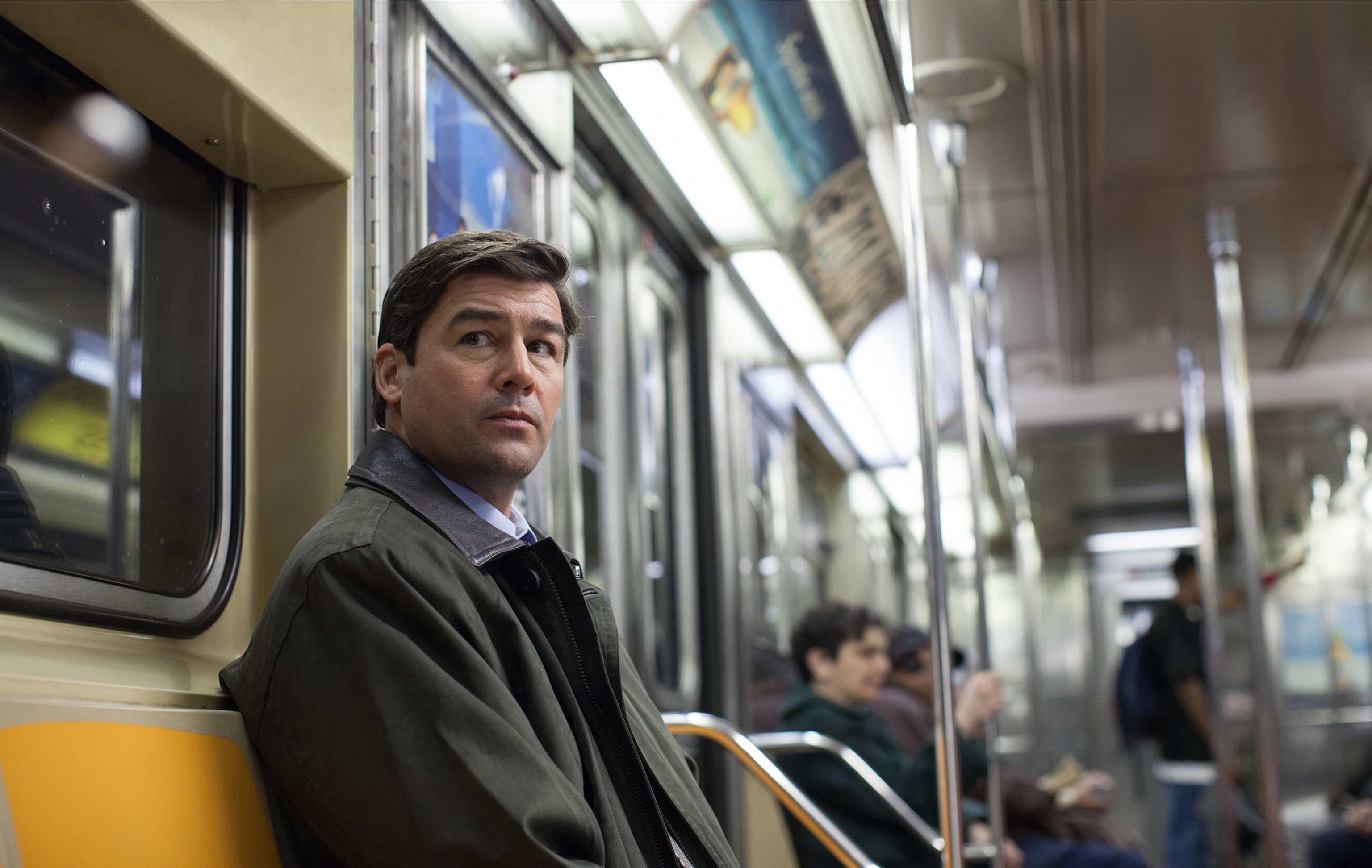 Kyle Chandler Sitting Thoughtfully on Subway Seat HD Wallpaper