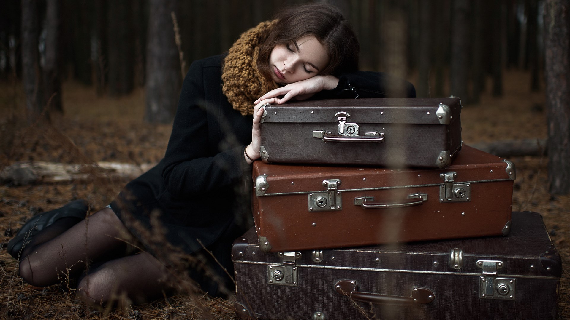 Woman sleeping on suitcases in a forest HD Wallpaper
