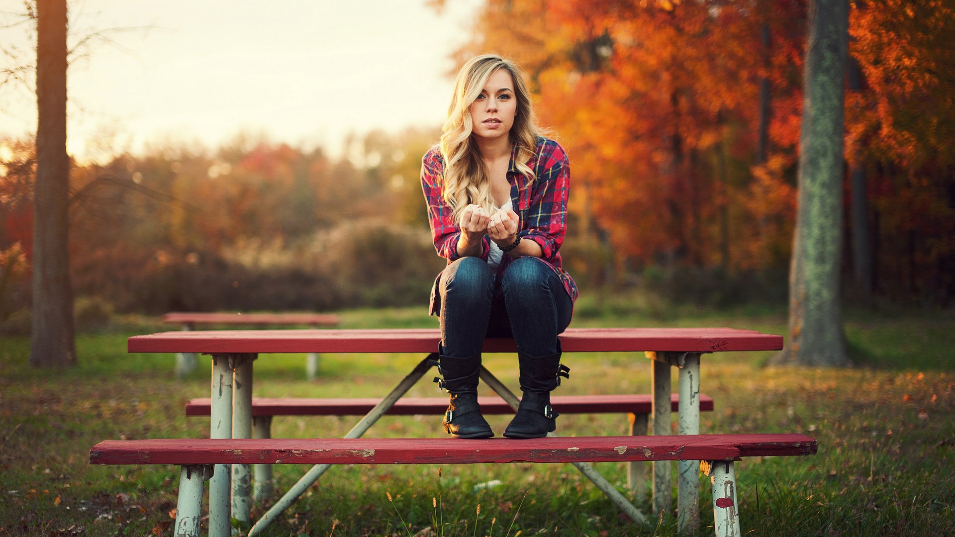 Woman sitting on a picnic table in autumn HD Wallpaper