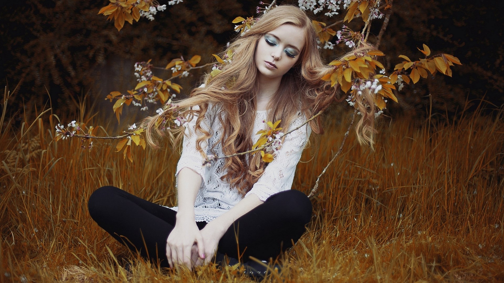 Young woman with long blonde hair sitting in grass HD Wallpaper