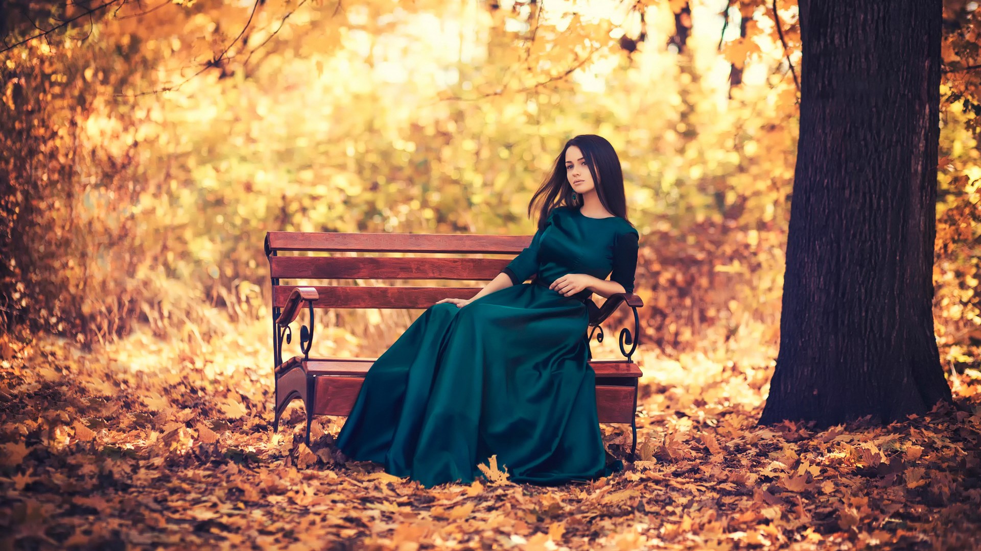 Woman in a green dress sitting on a park bench HD Wallpaper