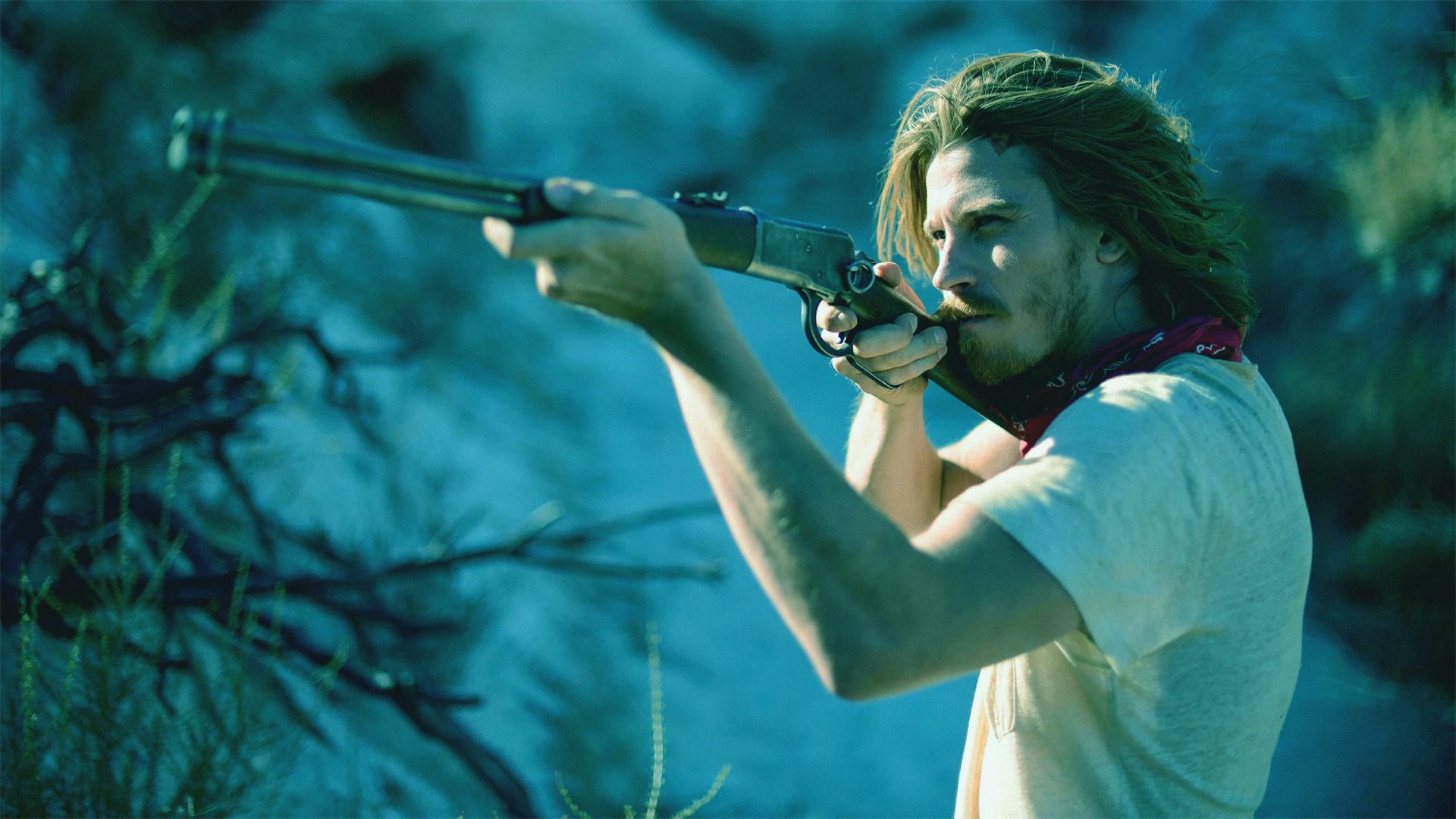 Garrett Hedlund aiming a rifle in a desert HD Wallpaper