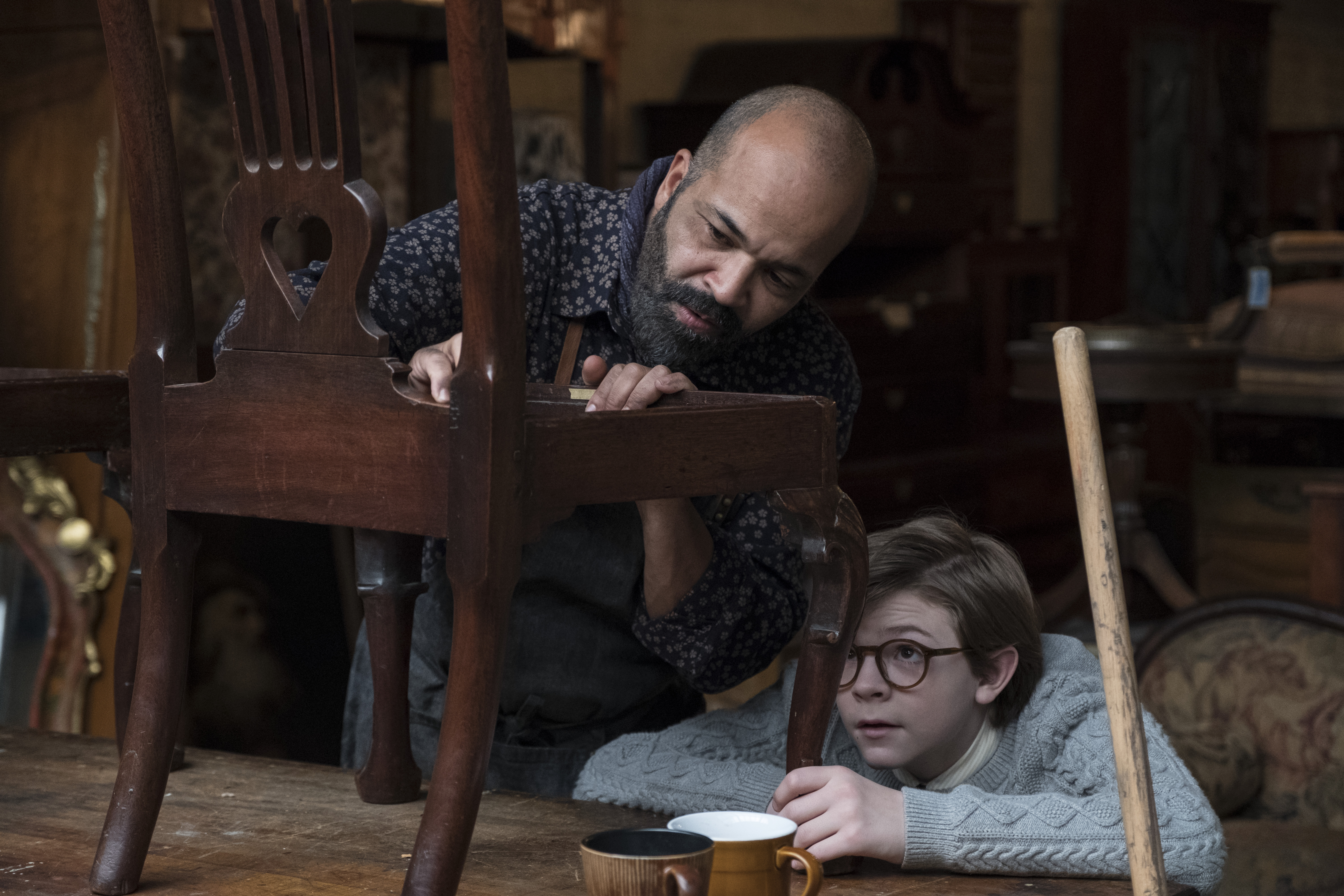 Jeffrey Wright and Oakes Fegley examine a chair HD Wallpaper