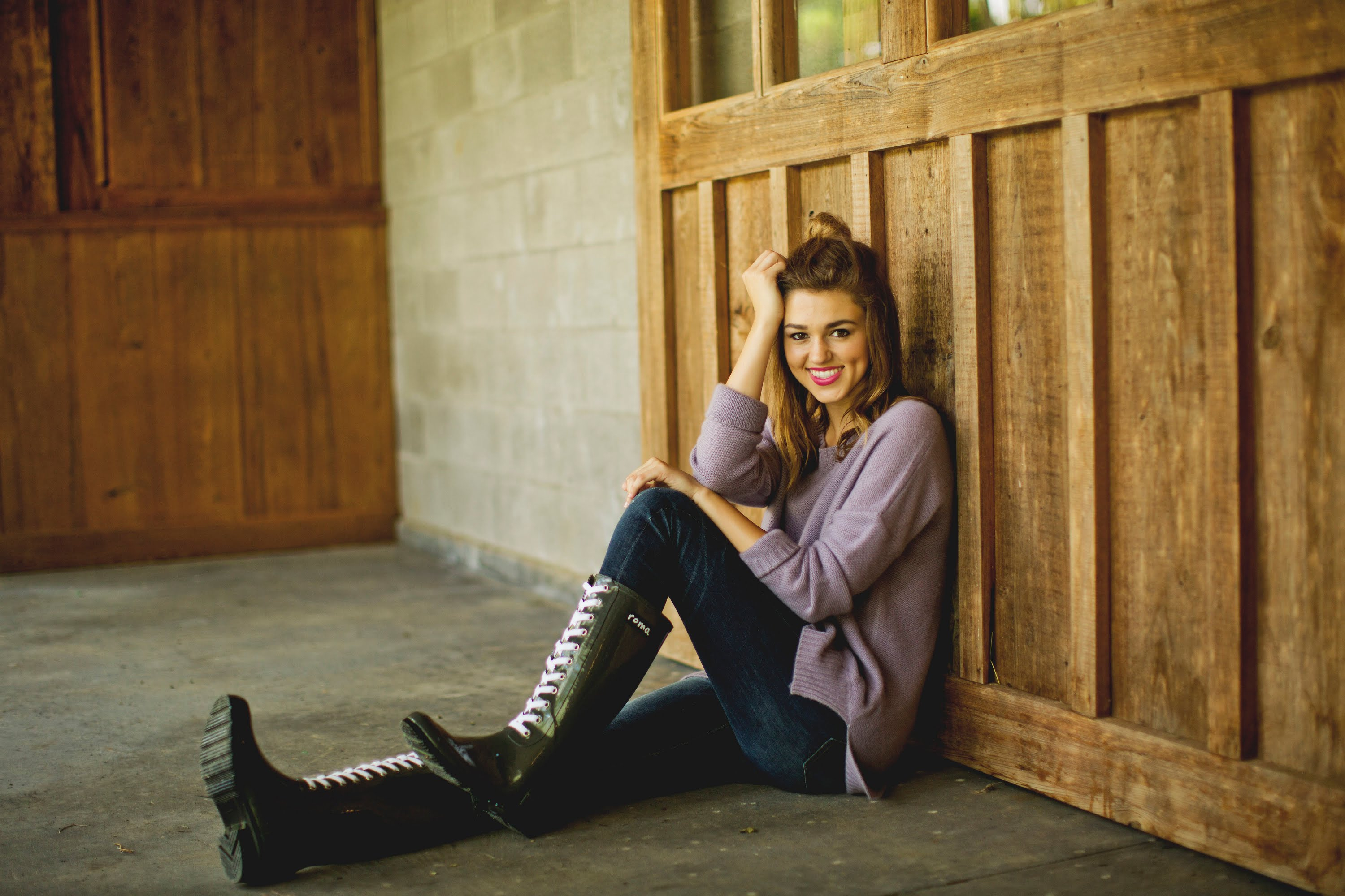 Sadie Robertson sitting by wooden wall HD Wallpaper