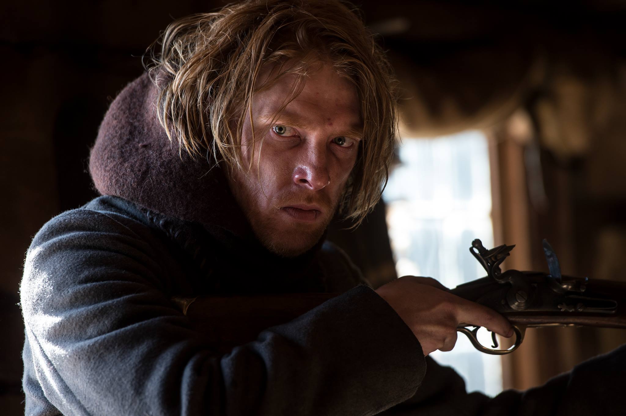 Domhnall Gleeson holding a rifle HD Wallpaper