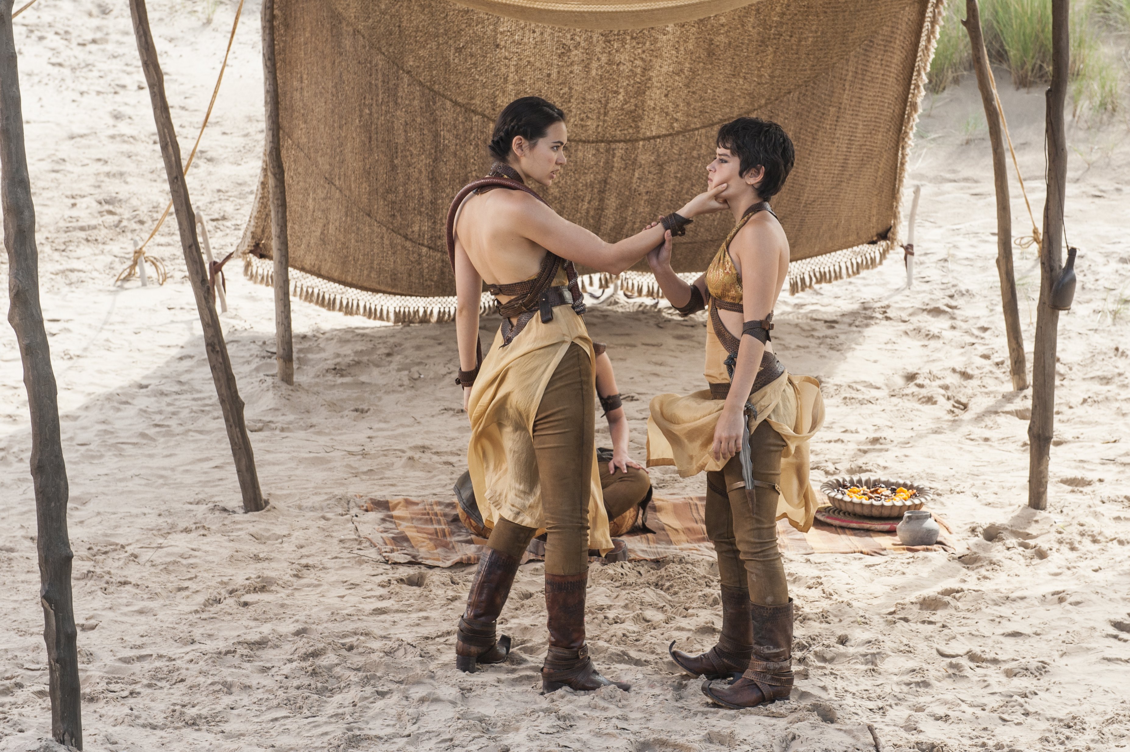 Two women in desert attire under a tent HD Wallpaper