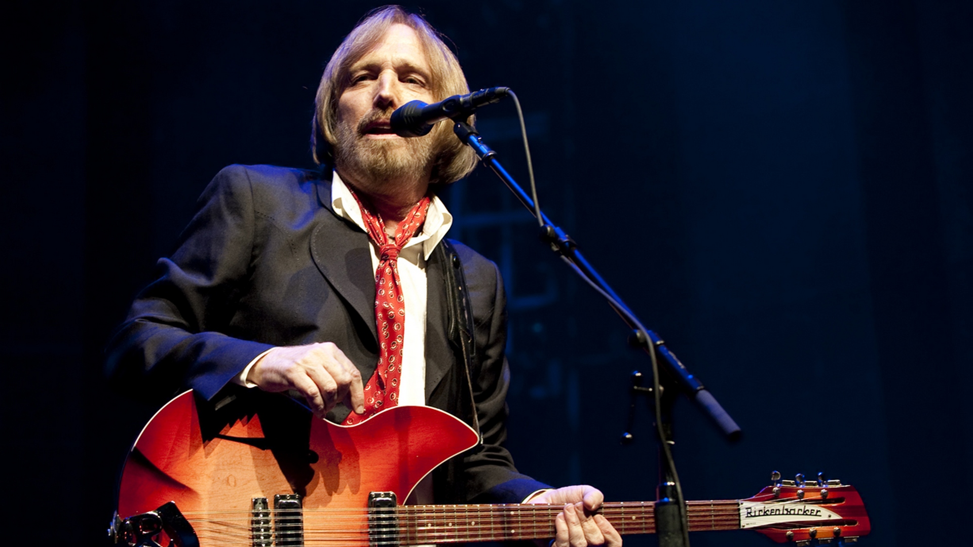 Tom Petty performing on stage with a guitar HD Wallpaper
