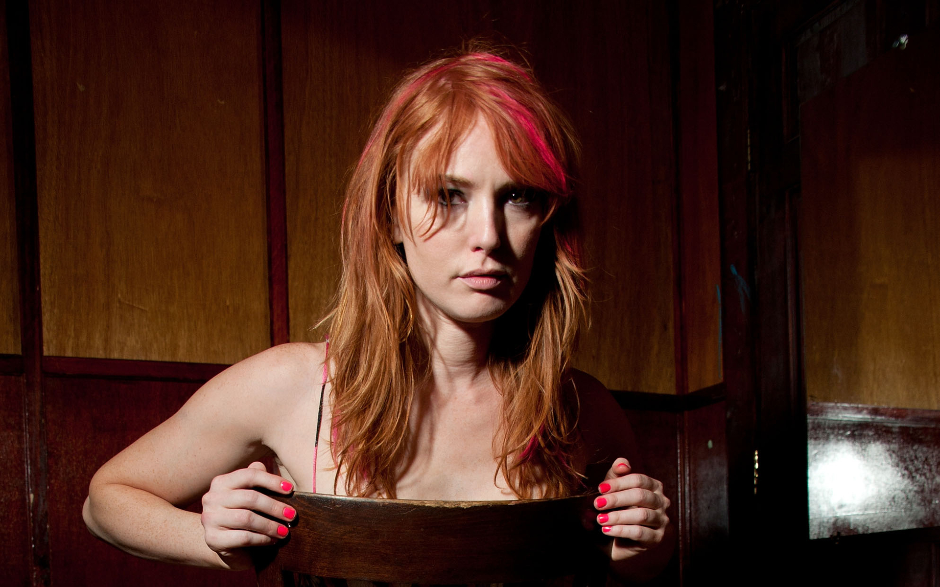 Alicia Witt sitting behind a wooden chair HD Wallpaper