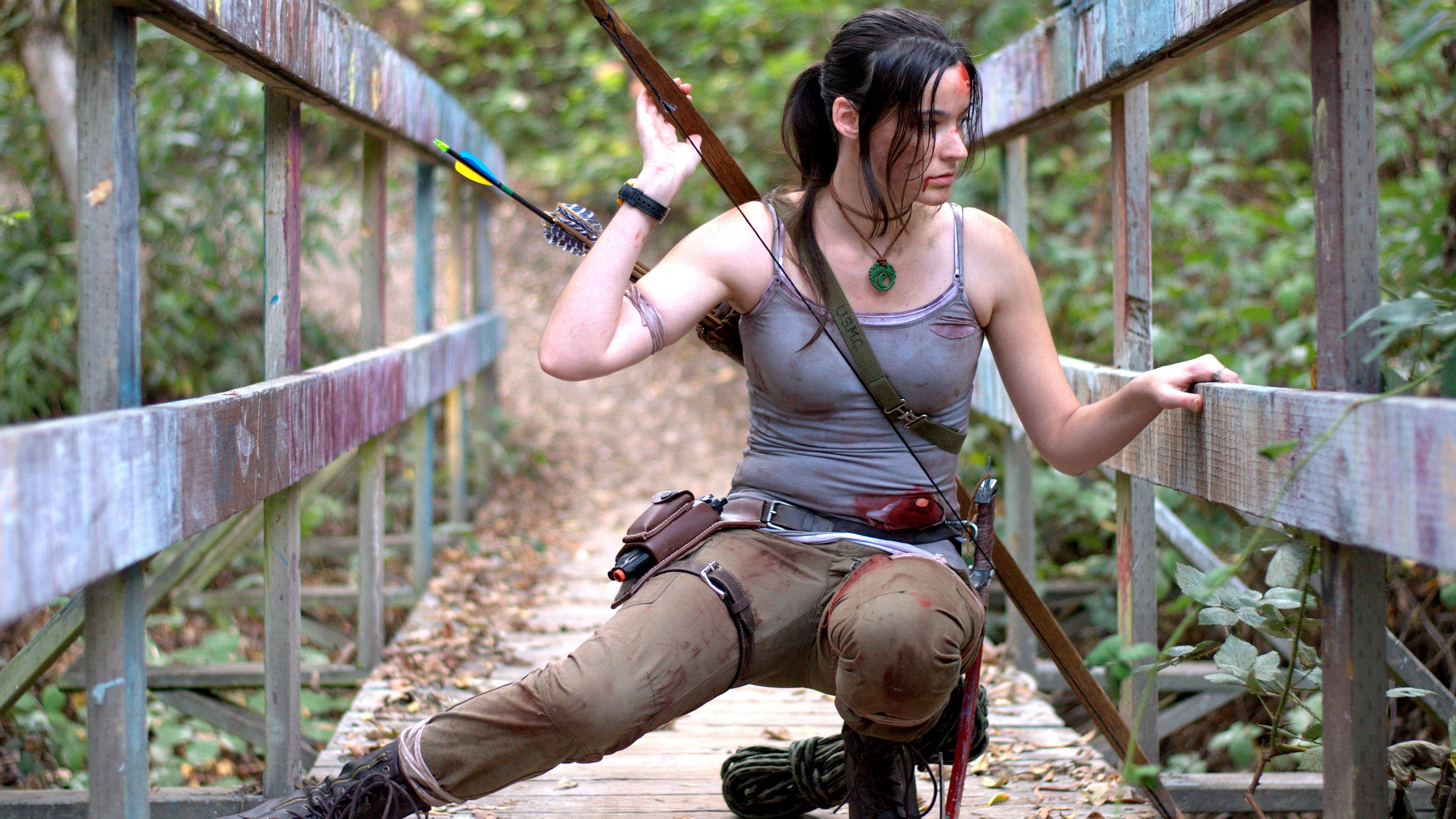 Lara Croft with bow and arrow on a bridge HD Wallpaper