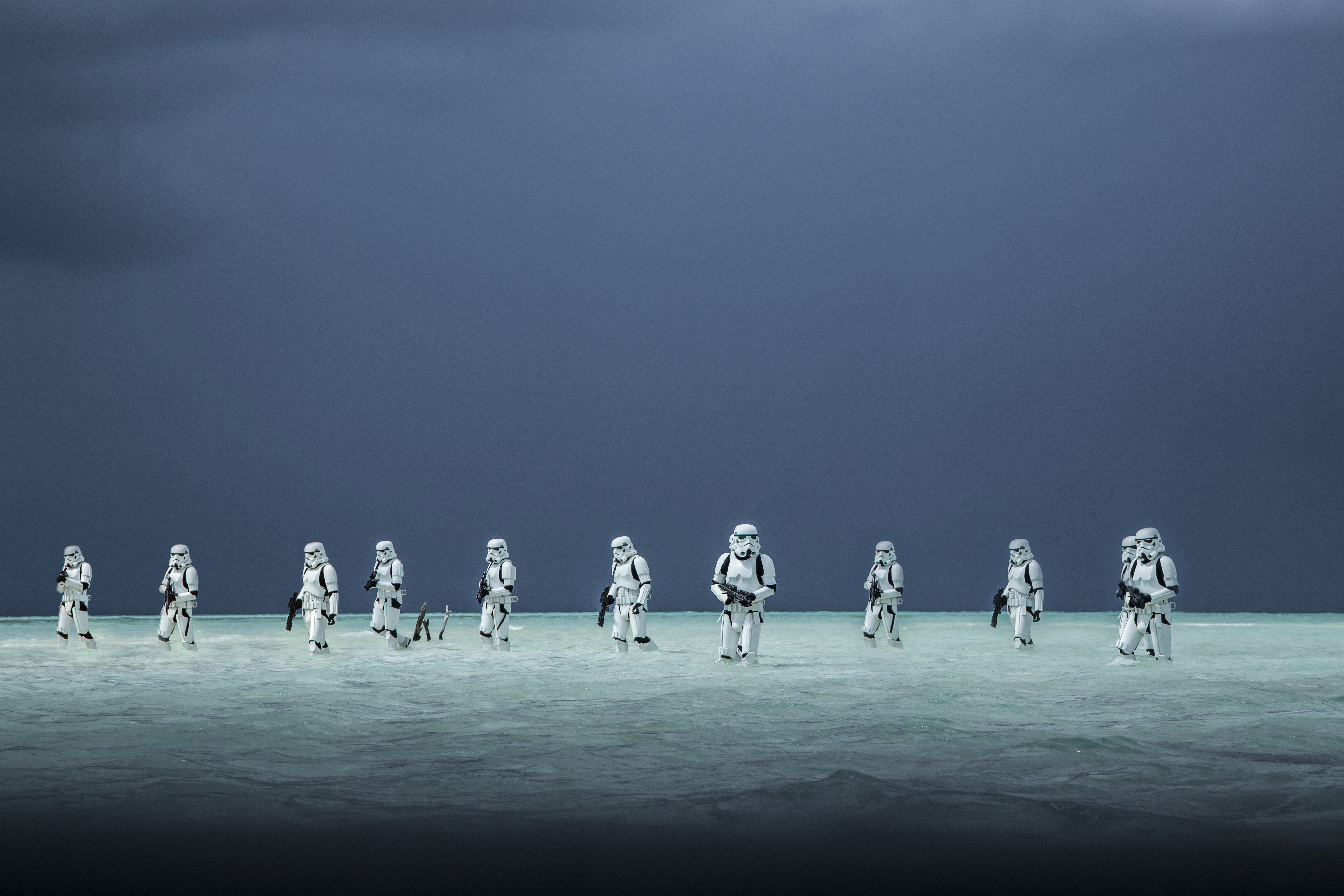 Stormtroopers walking in shallow water under a dark sky HD Wallpaper
